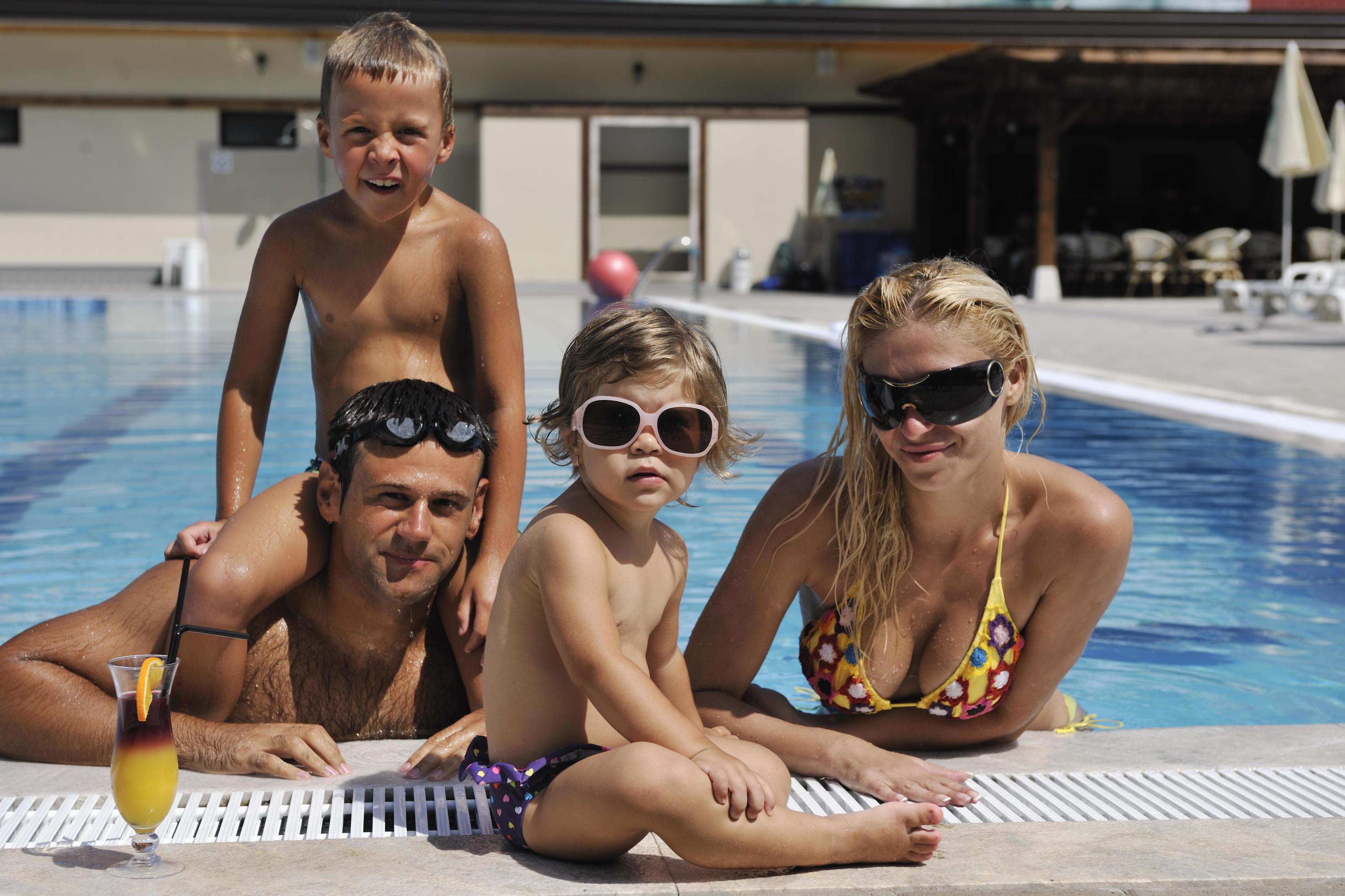 happy young family have fun on swimming pool Stock Free