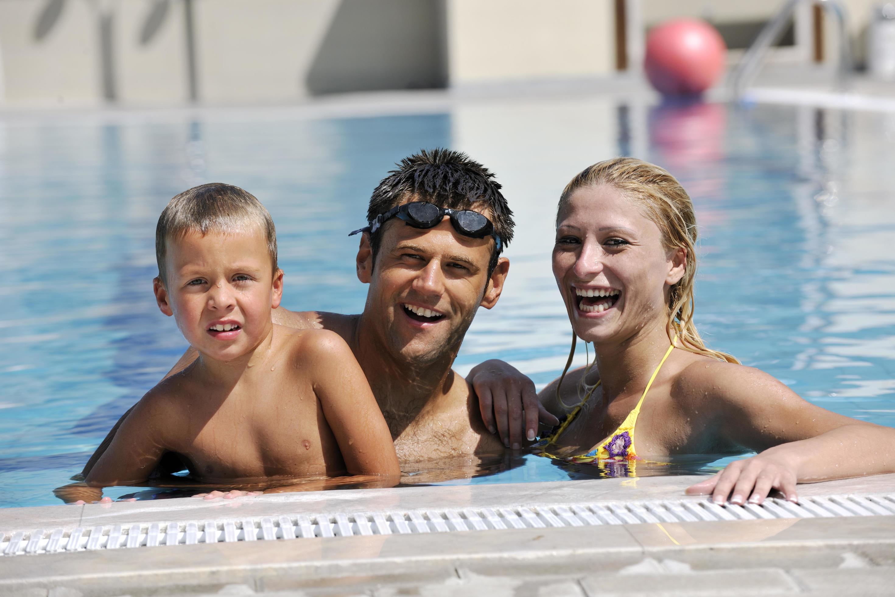 happy young family have fun on swimming pool Stock Free