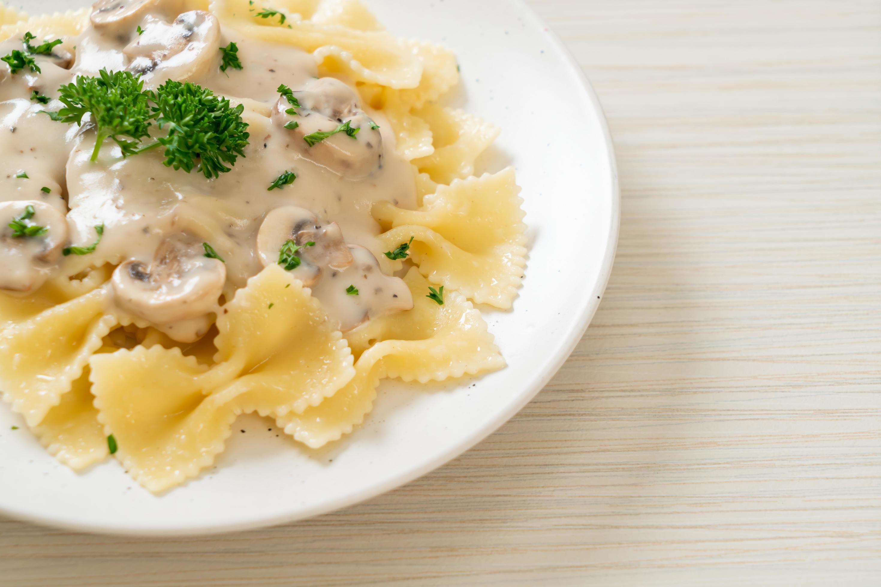 
									Farfalle pasta with mushroom white cream sauce – Italian food style Stock Free