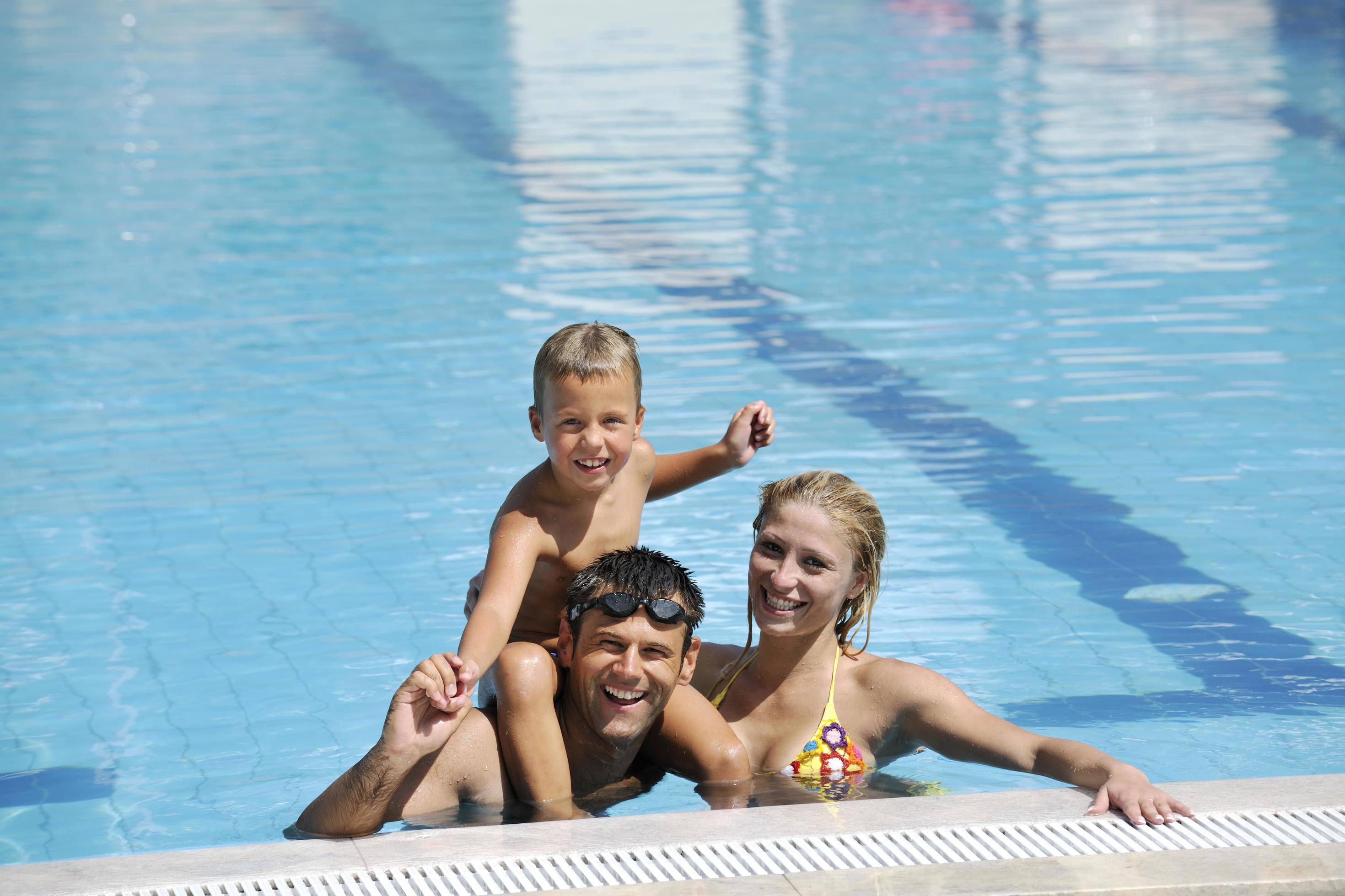 happy young family have fun on swimming pool Stock Free