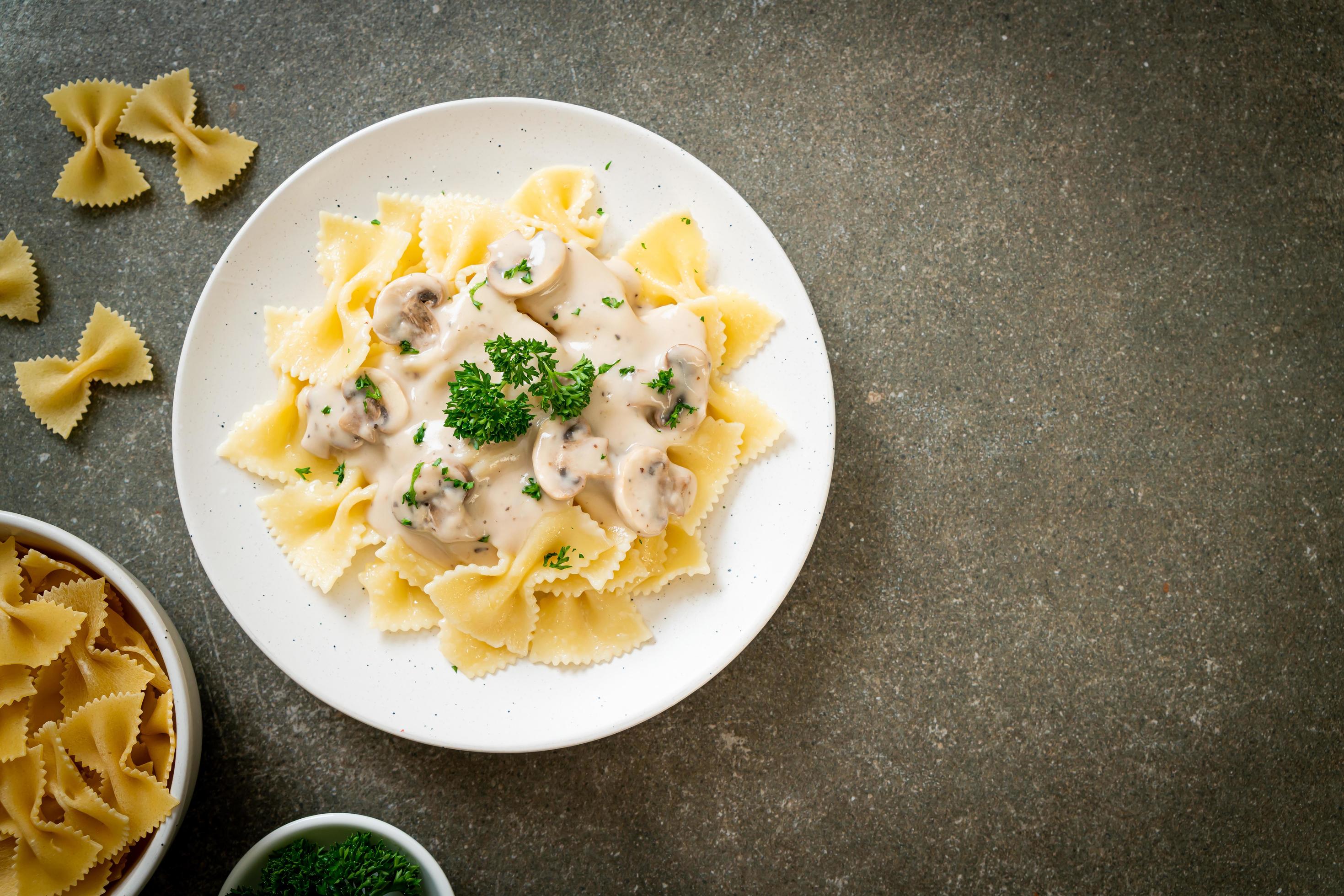 Farfalle pasta with mushroom white cream sauce – Italian food style Stock Free