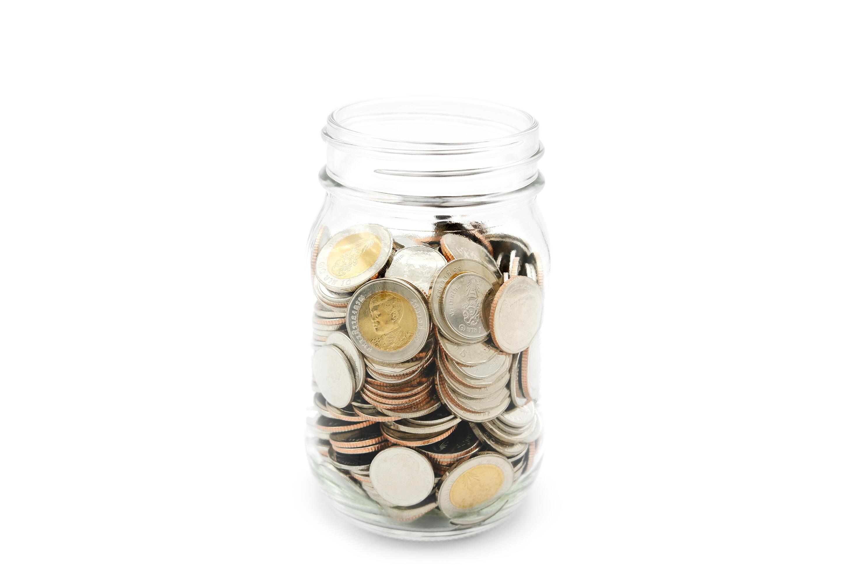 Thai Baht coins in a glass jar. Business and finance concept. Stock Free