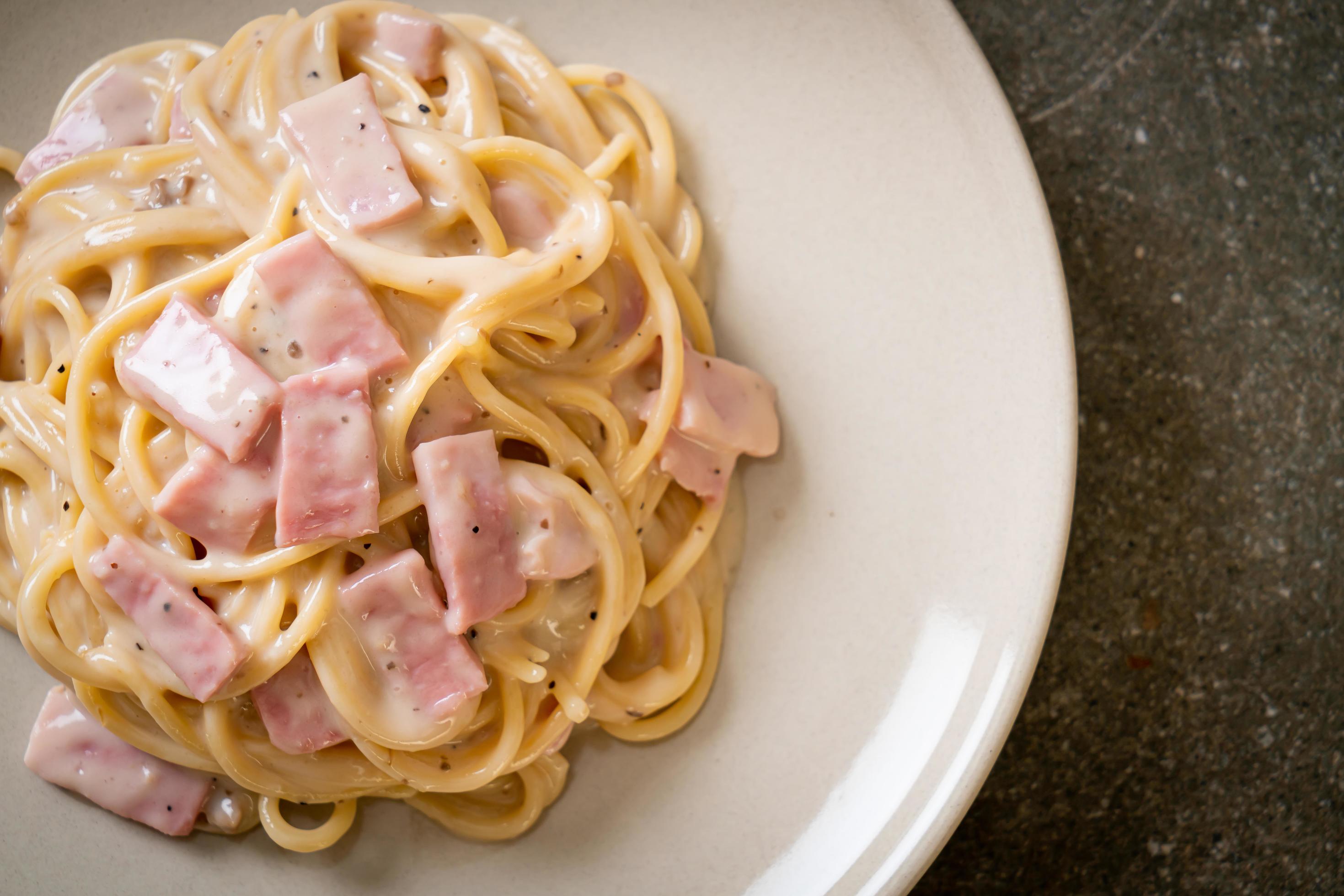 Homemade spaghetti white cream sauce with ham – Italian food style Stock Free