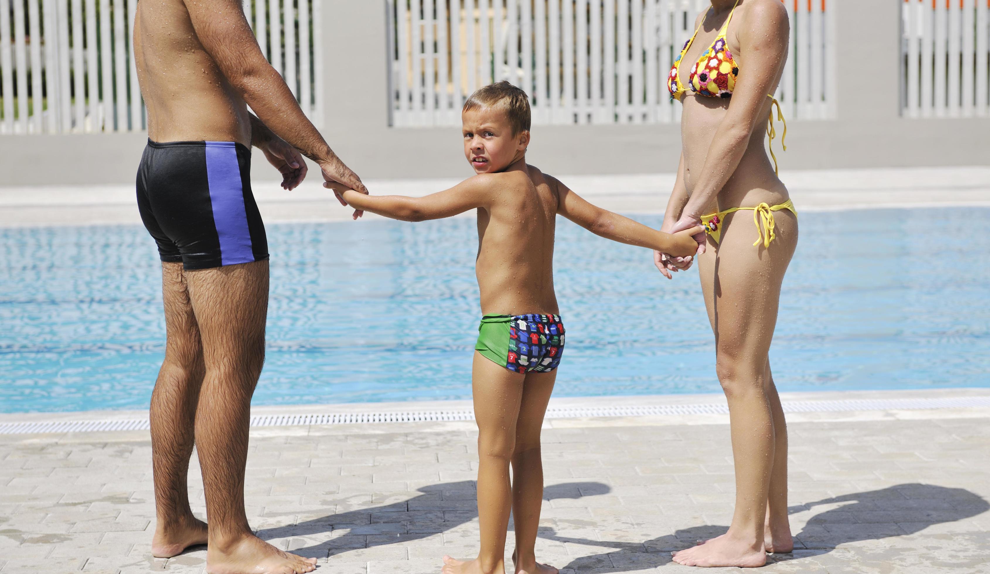 happy young family have fun on swimming pool Stock Free