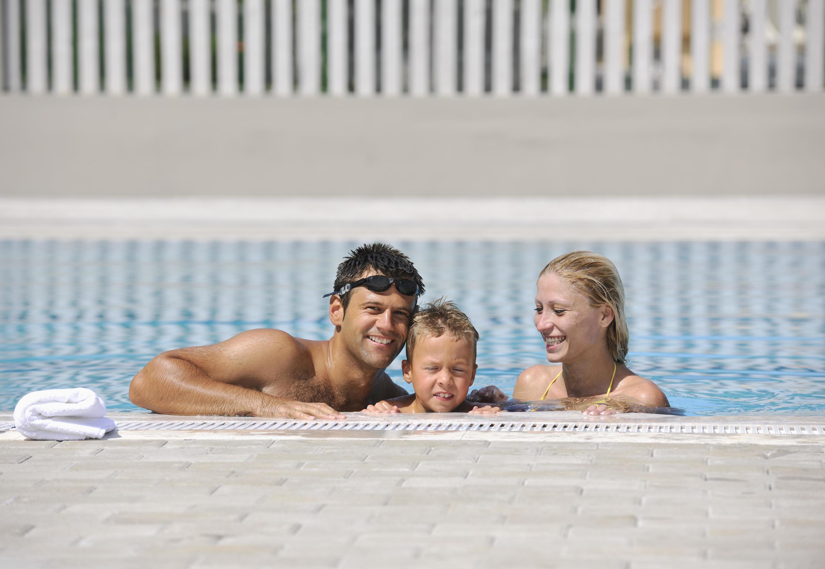 happy young family have fun on swimming pool Stock Free