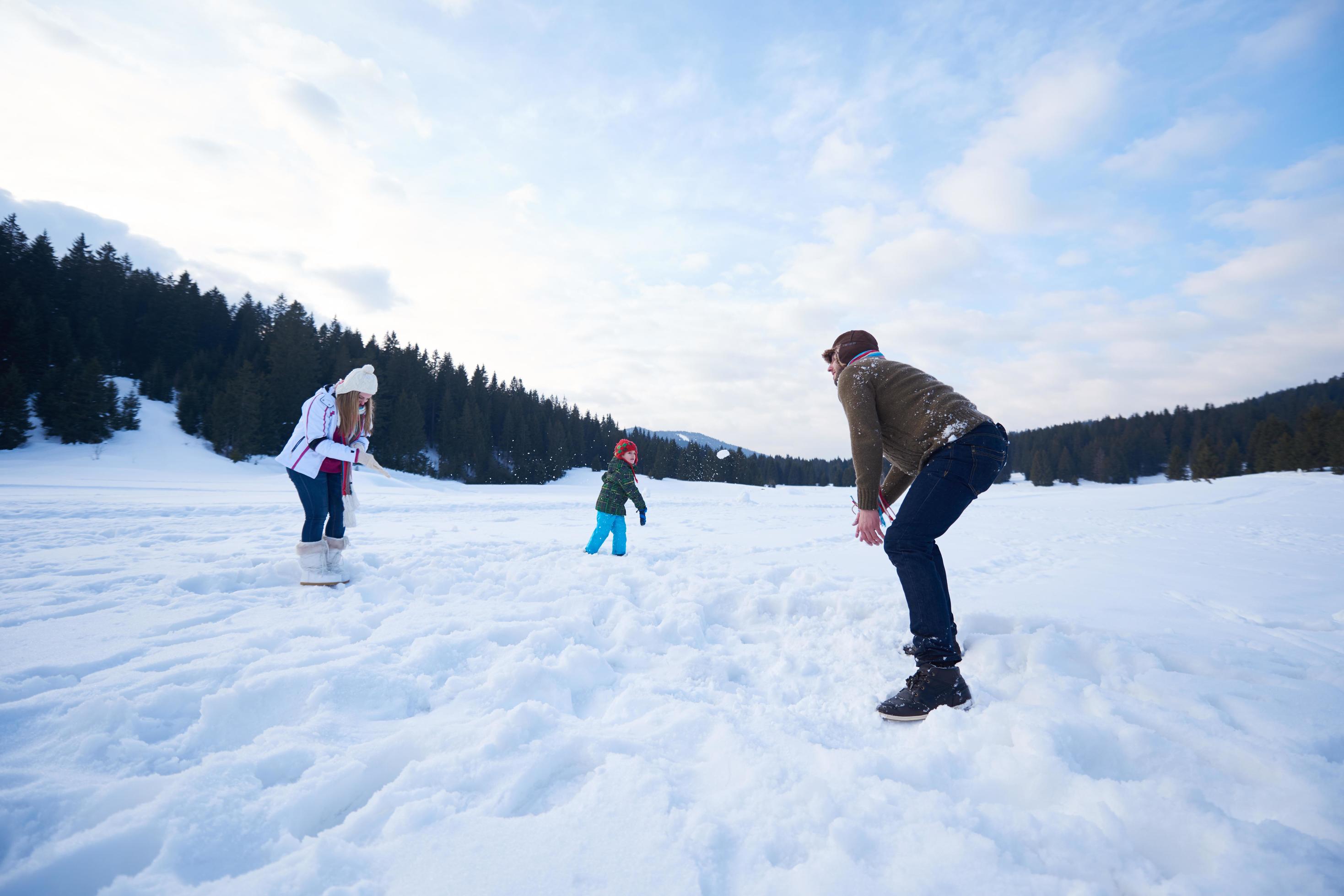 happy family playing together in snow at winter Stock Free