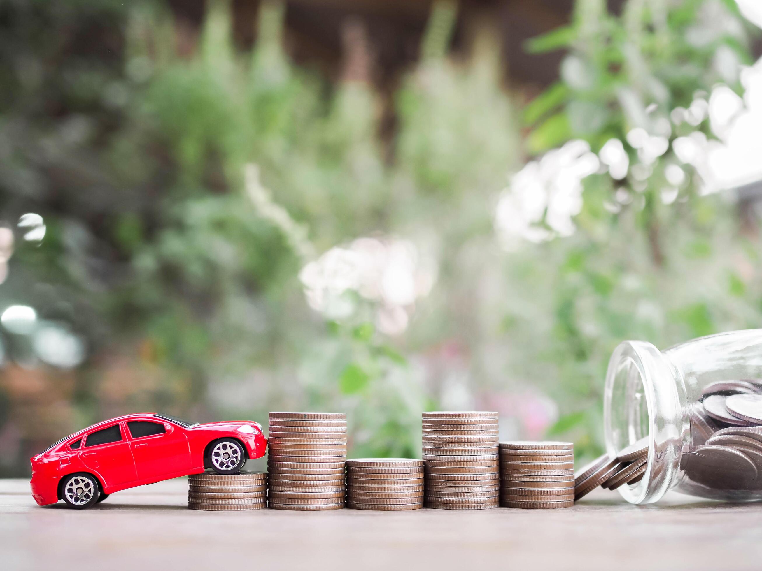 Toy cars on stack of coins. The concept of saving money and manage to success transport business Stock Free