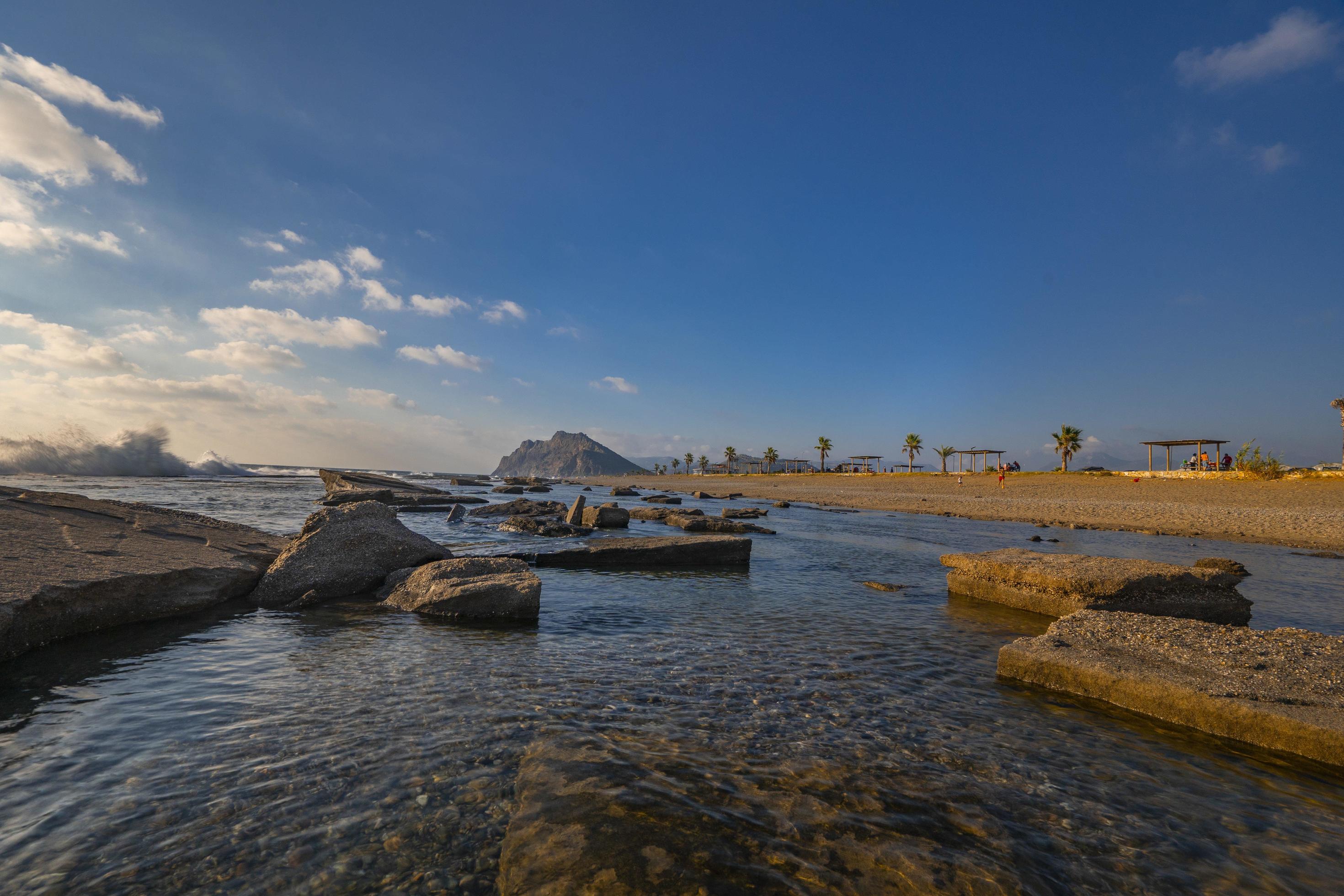 Long exposure photography of waves and pebbles on Beach in the sunset Stock Free