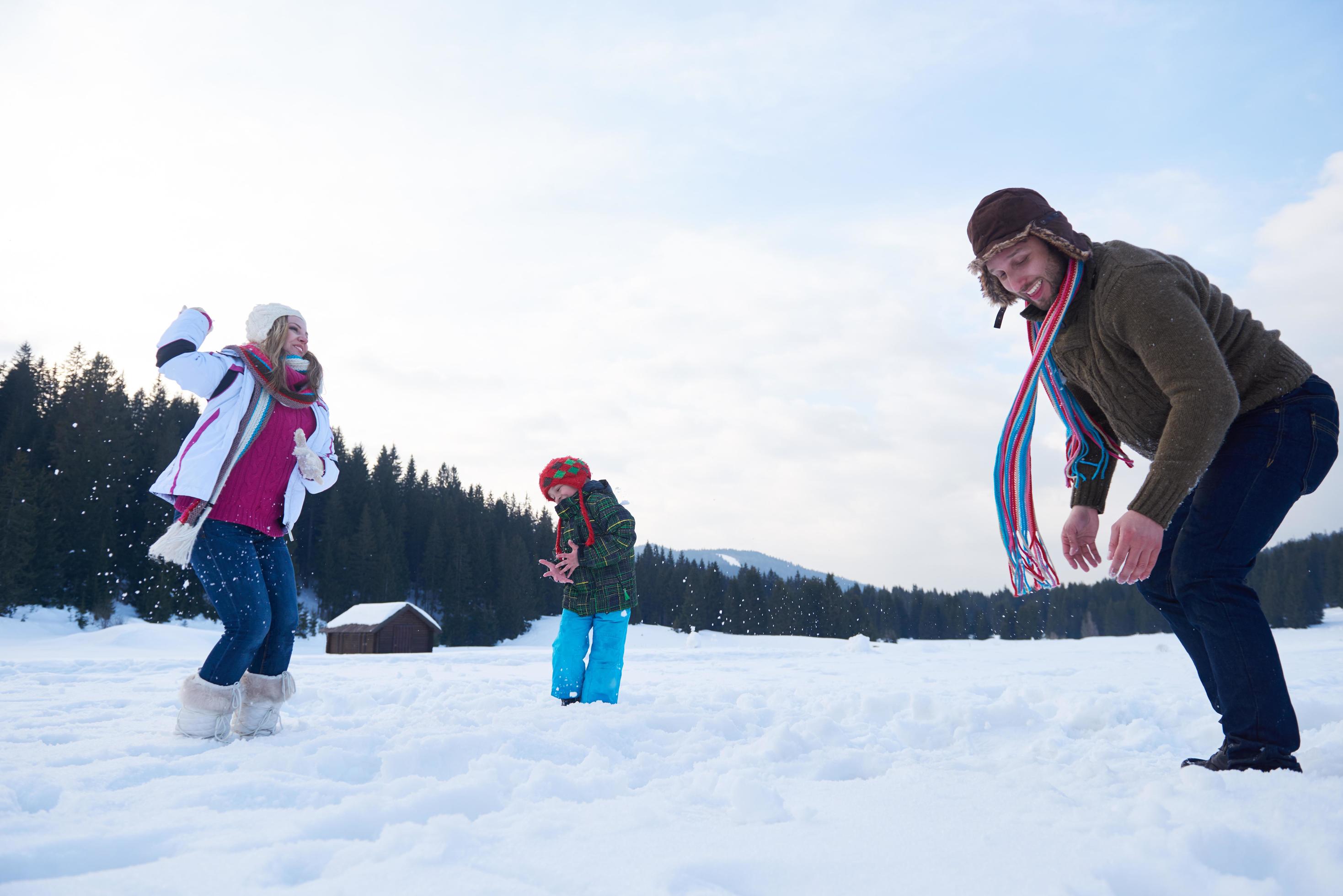 happy family playing together in snow at winter Stock Free