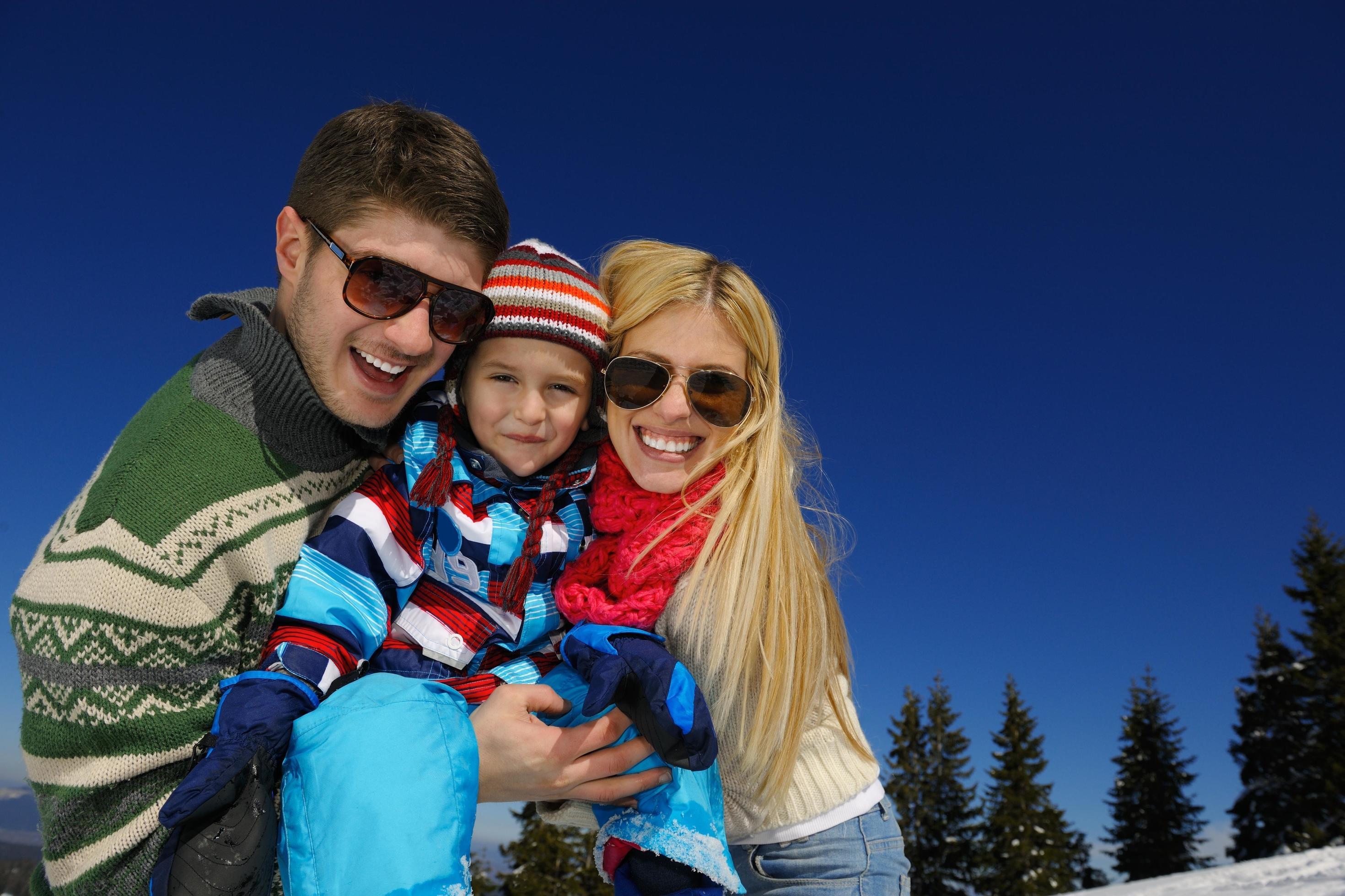 family having fun on fresh snow at winter vacation Stock Free