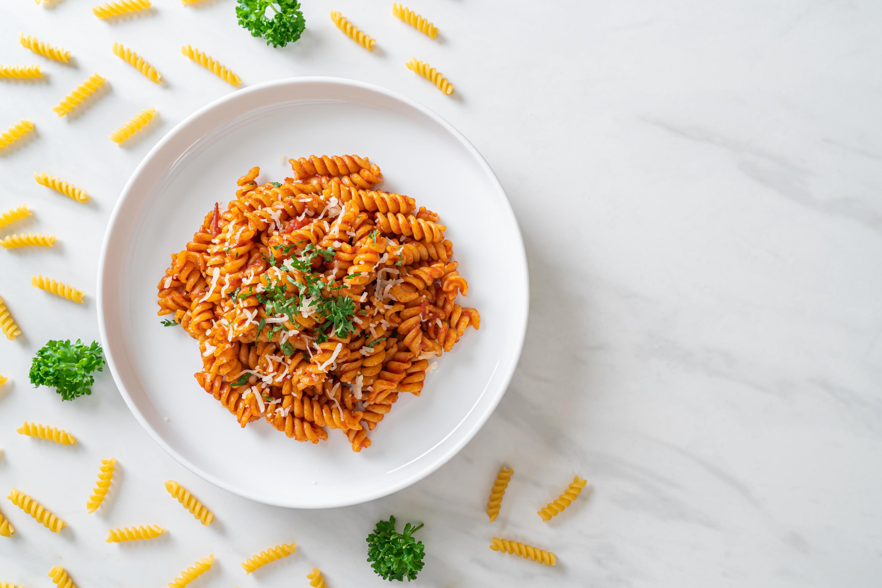 Spiral or spirali pasta with tomato sauce and sausage – Italian food style Stock Free