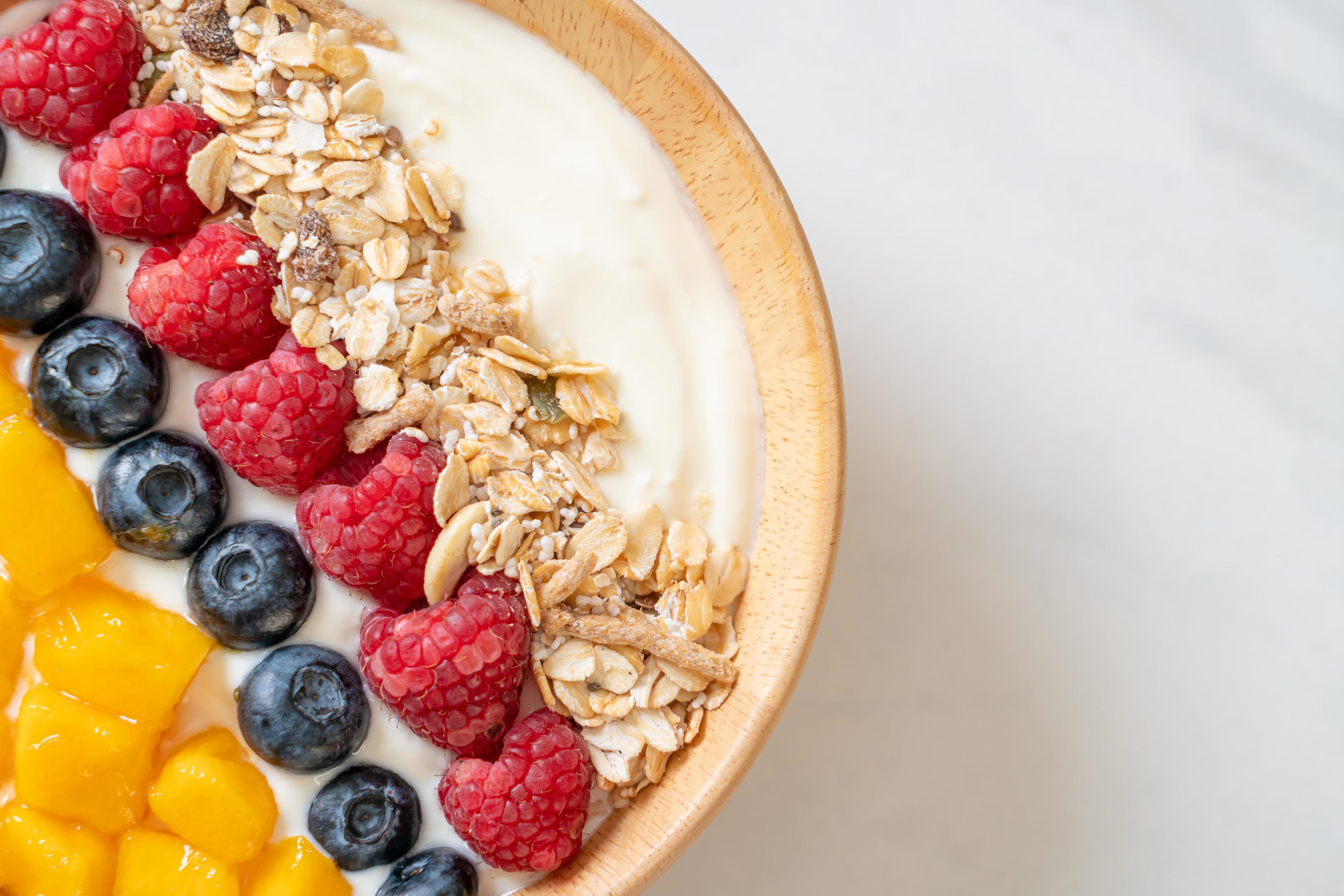 Homemade yogurt bowl with raspberry, blueberry, mango and granola – healthy food style Stock Free