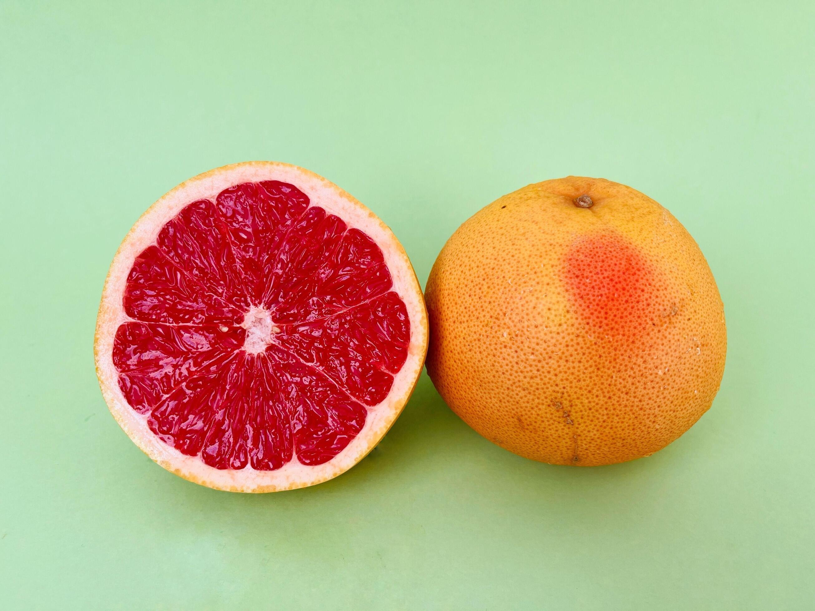 Fresh grapefruit fruit. Grapefruit isolated on green background. Grapefruit with clipping path. Stock Free