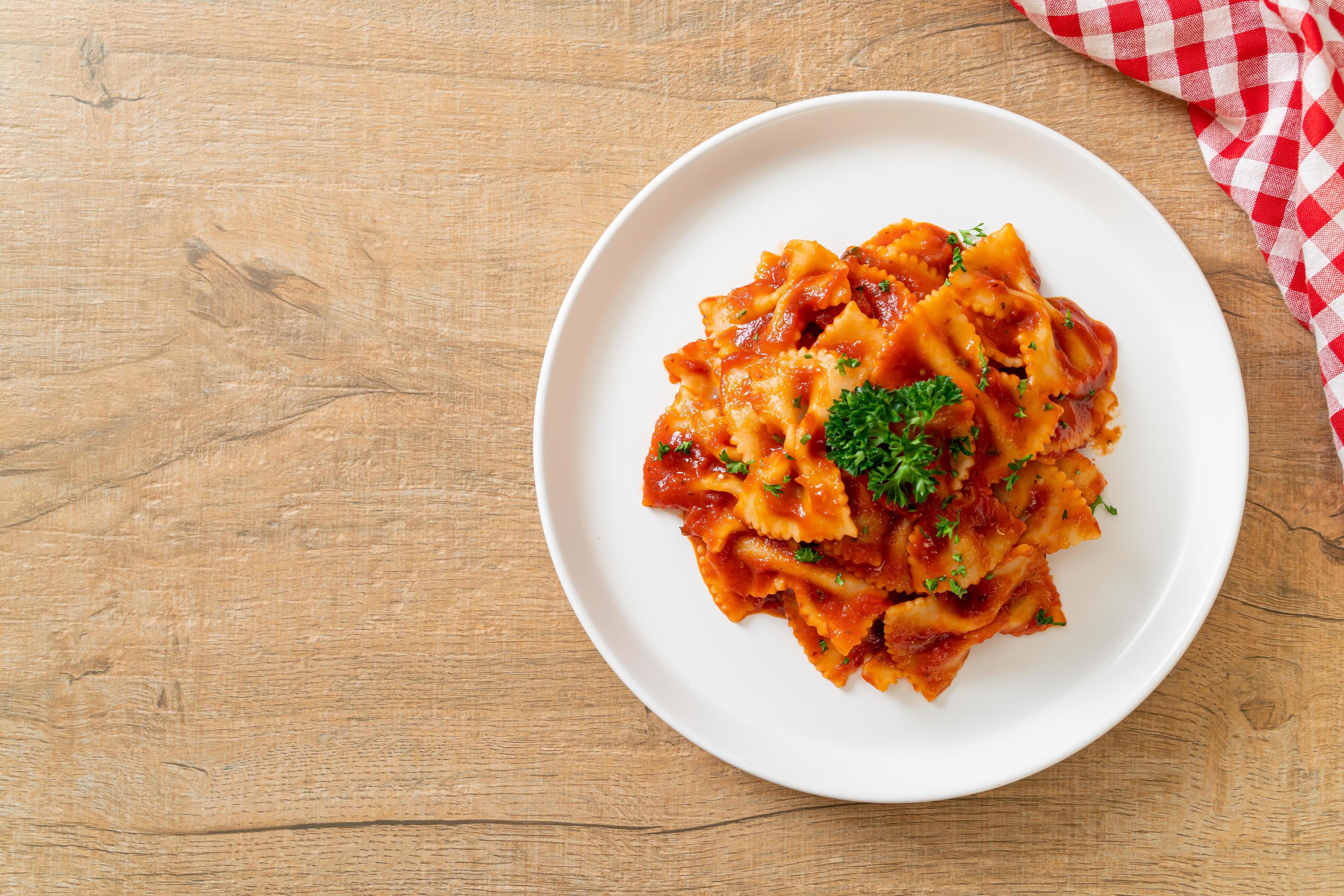 Farfalle pasta in tomato sauce with parsley – Italian food style Stock Free