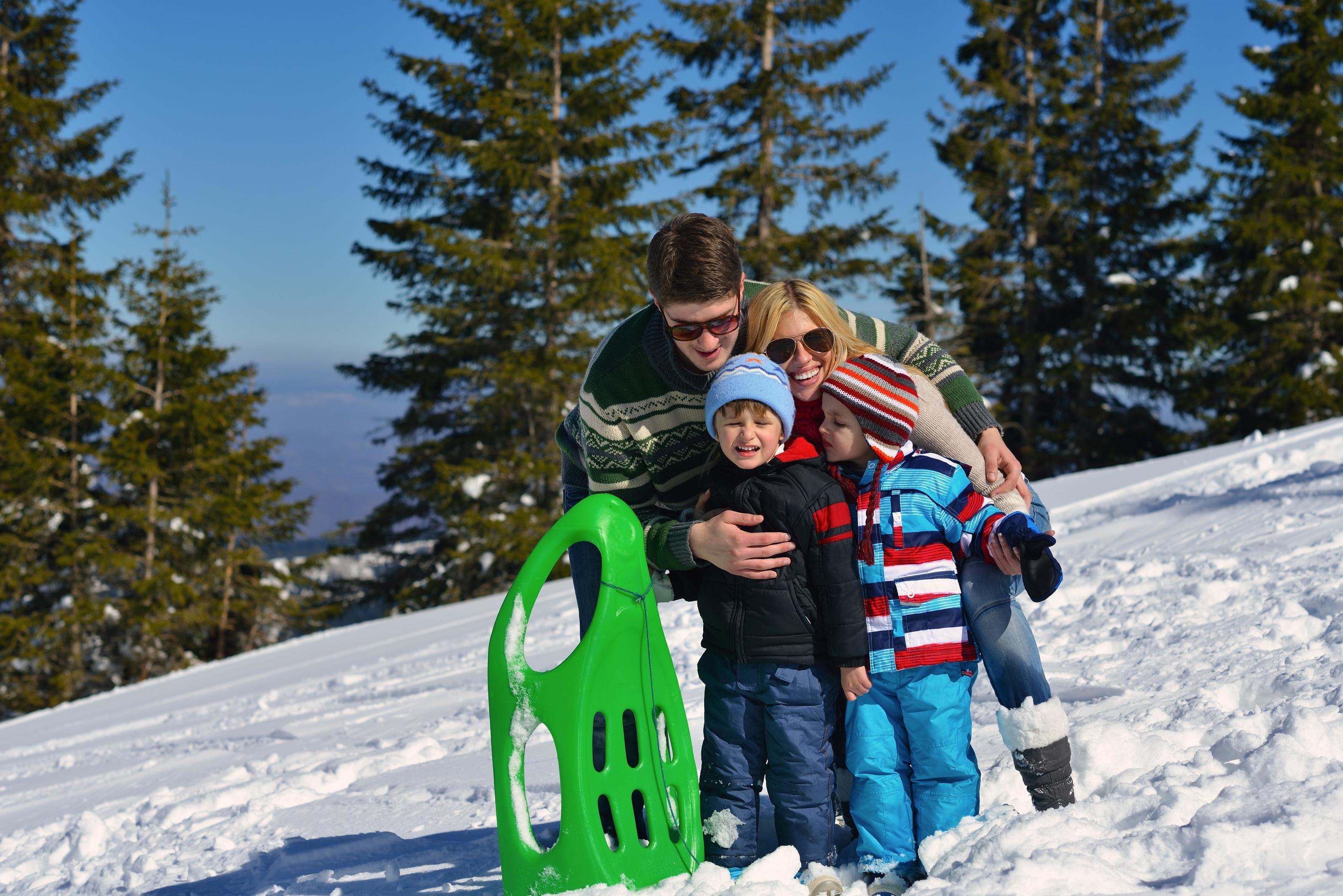 family having fun on fresh snow at winter vacation Stock Free