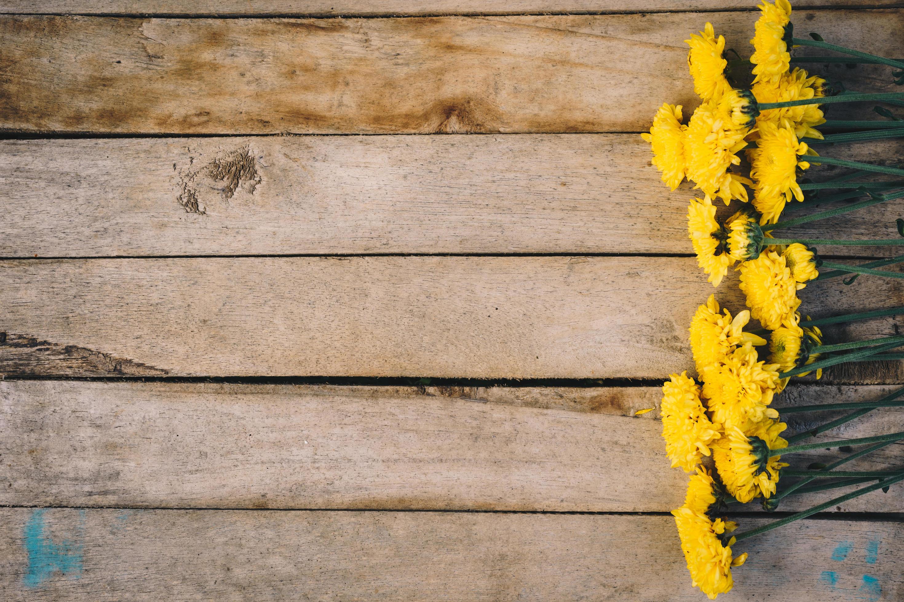 Yellow flowers of bouquet, top view on wooden background texture with copy space Stock Free