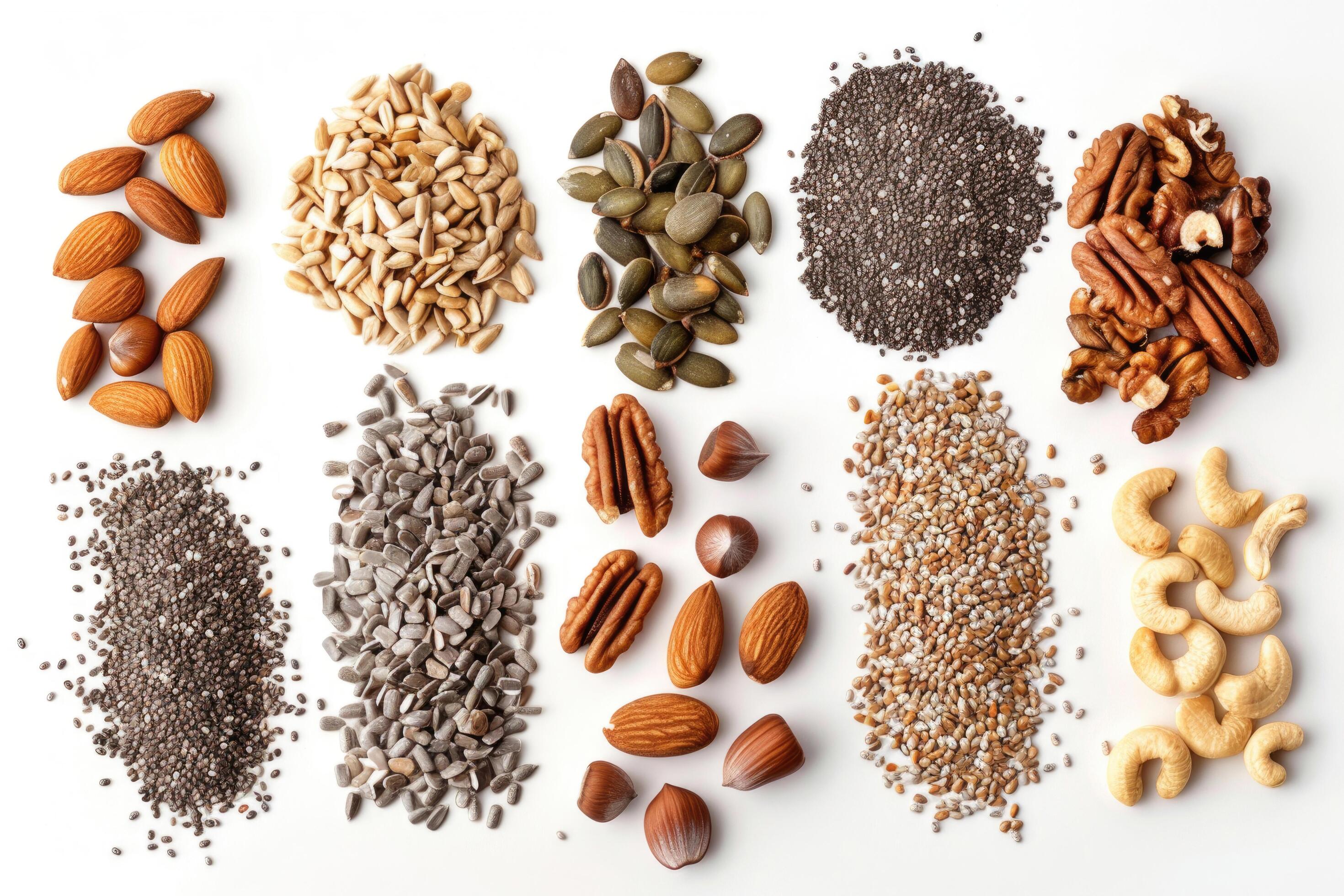 An assortment of nuts and seeds spread out on a white background Stock Free