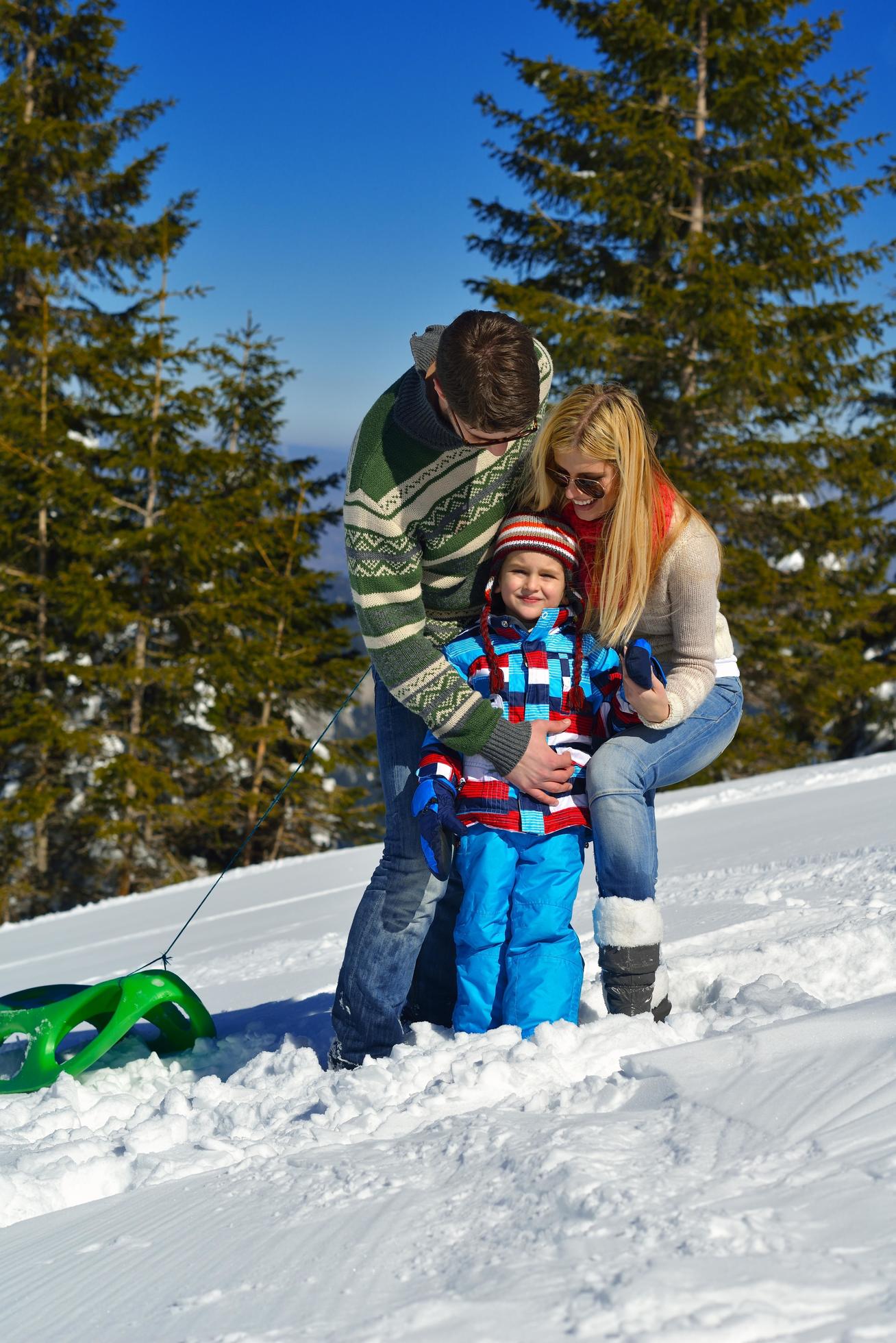 family having fun on fresh snow at winter vacation Stock Free