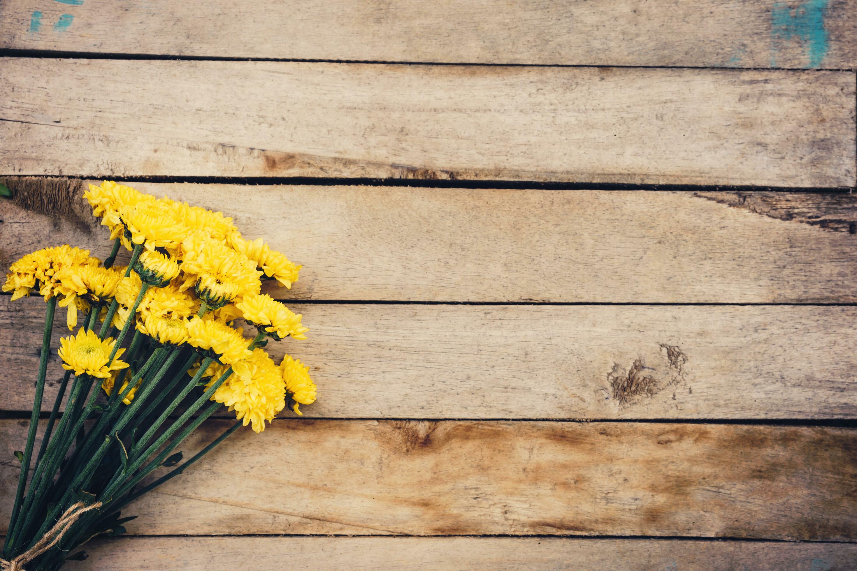 Yellow flowers of bouquet, top view on wooden background texture with copy space Stock Free