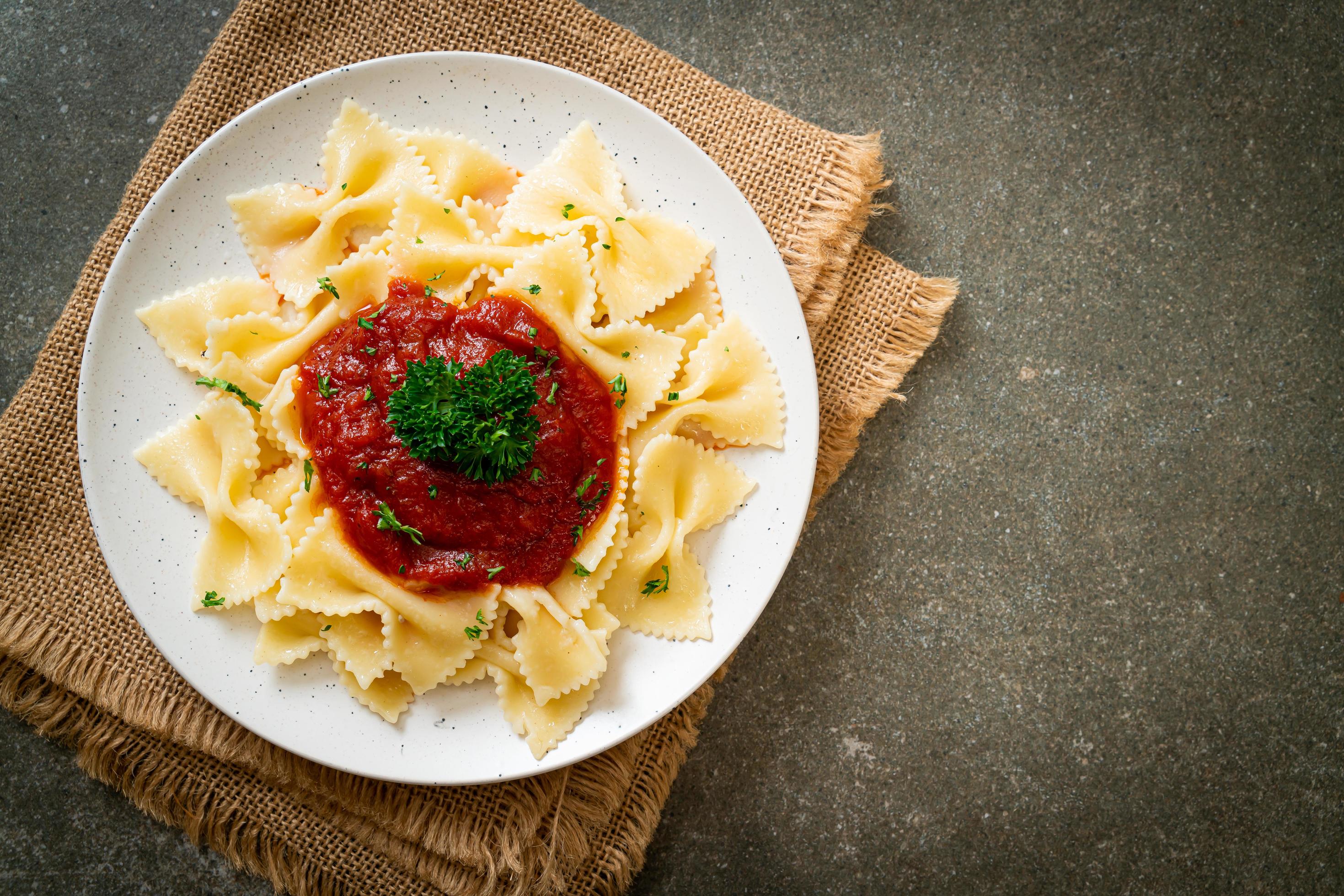 Farfalle pasta in tomato sauce with parsley – Italian food style Stock Free