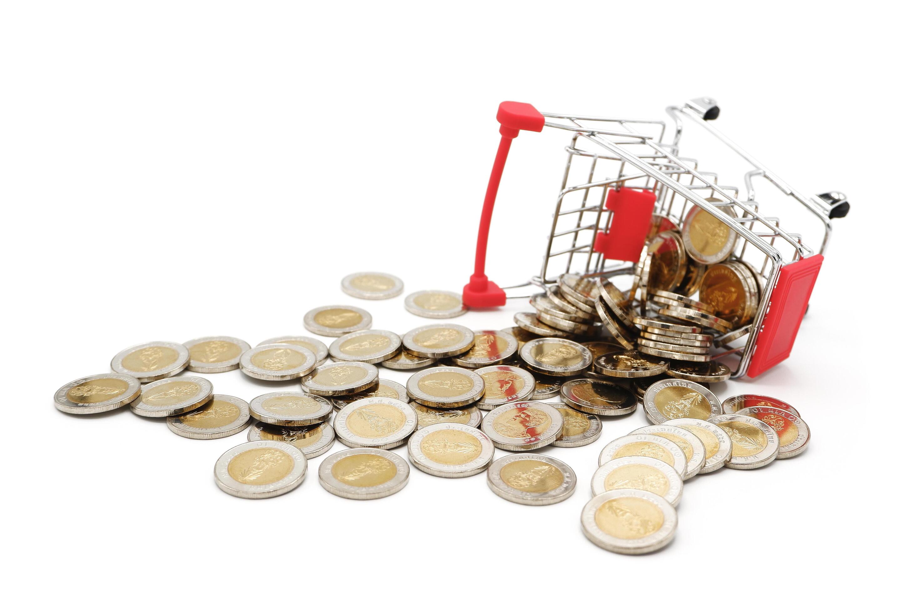 Red miniature shopping cart filled with new 10 Thai Baht coins, isolated on white background. Business concept. Stock Free