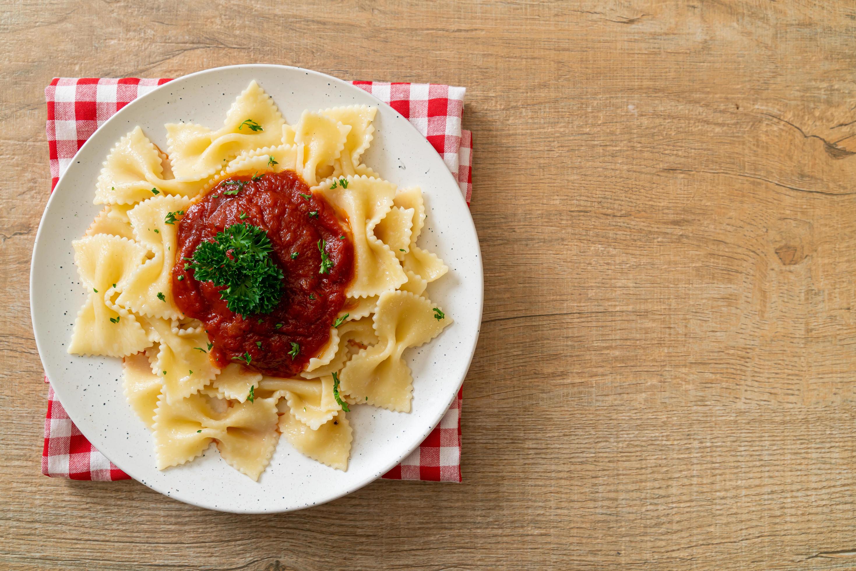 Farfalle pasta in tomato sauce with parsley – Italian food style Stock Free