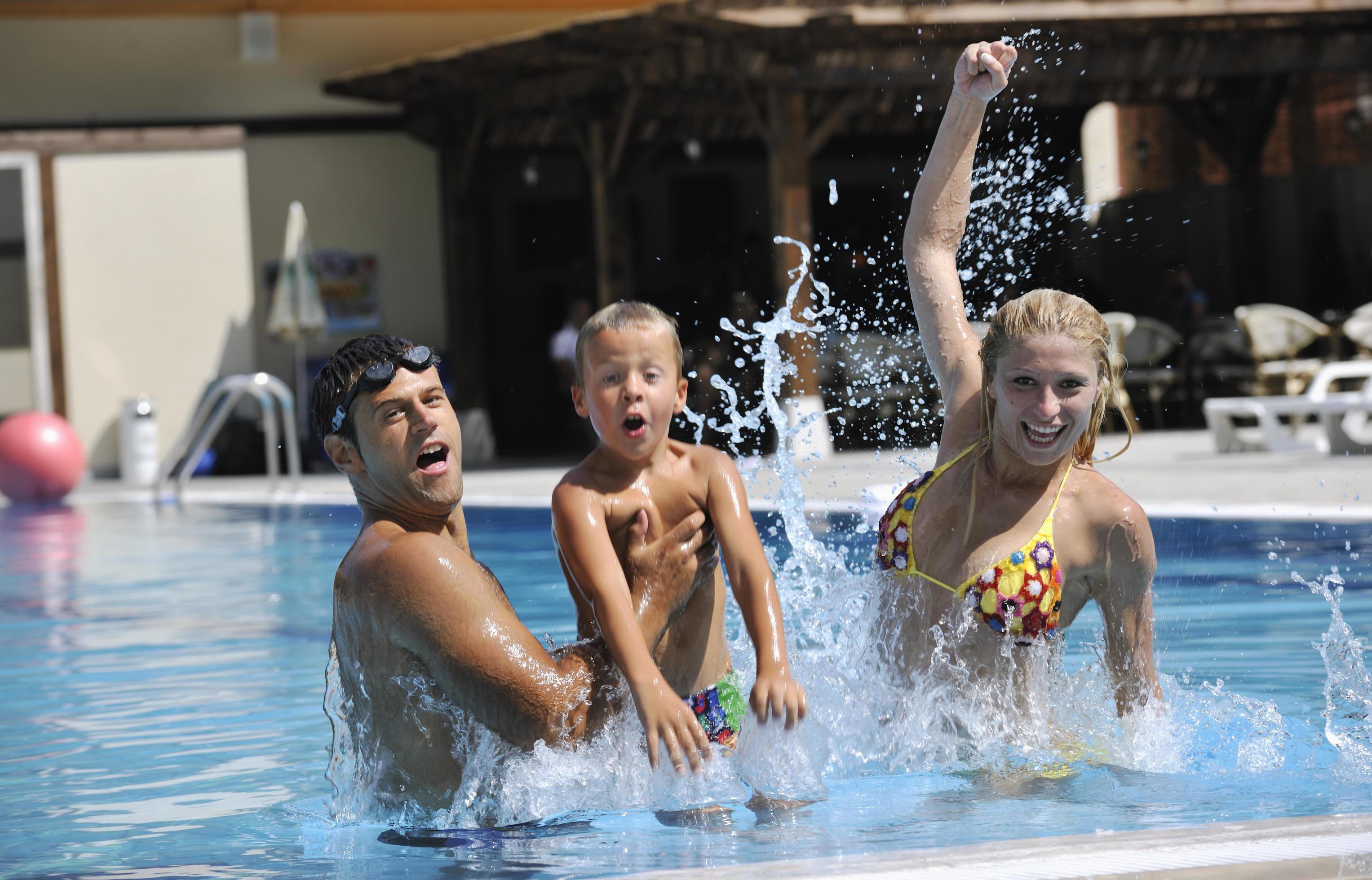 happy young family have fun on swimming pool Stock Free