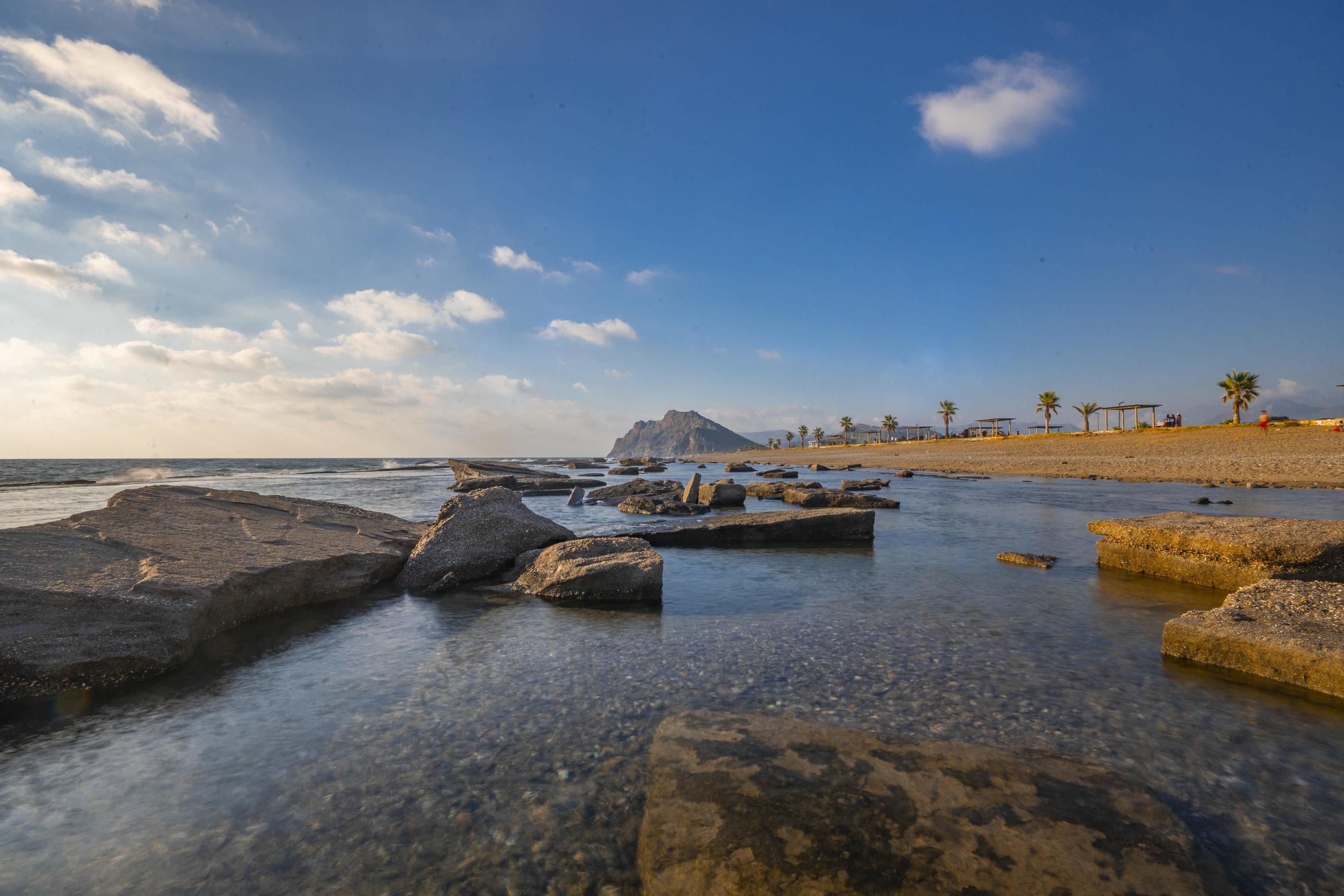 Long exposure photography of waves and pebbles on Beach in the sunset Stock Free