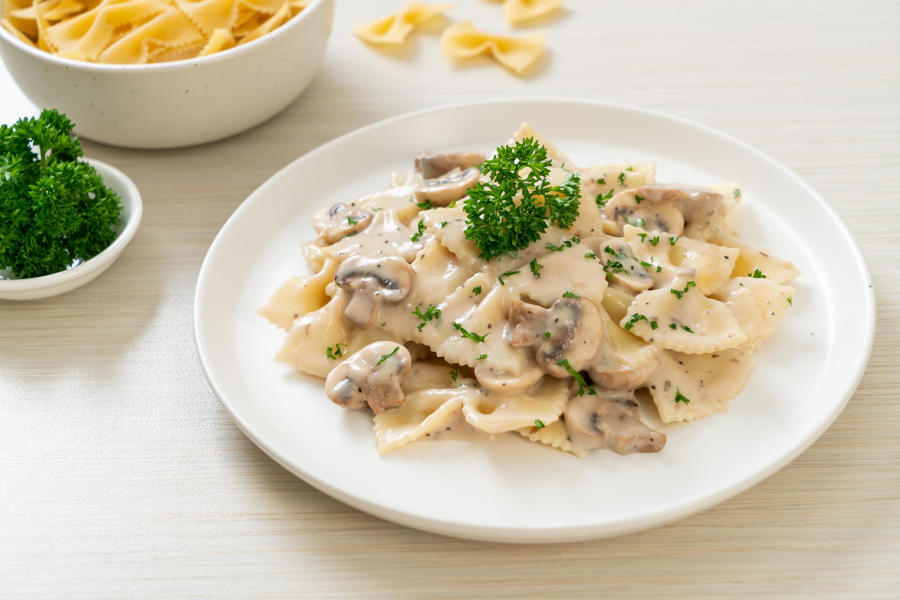 Farfalle pasta with mushroom white cream sauce – Italian food style Stock Free