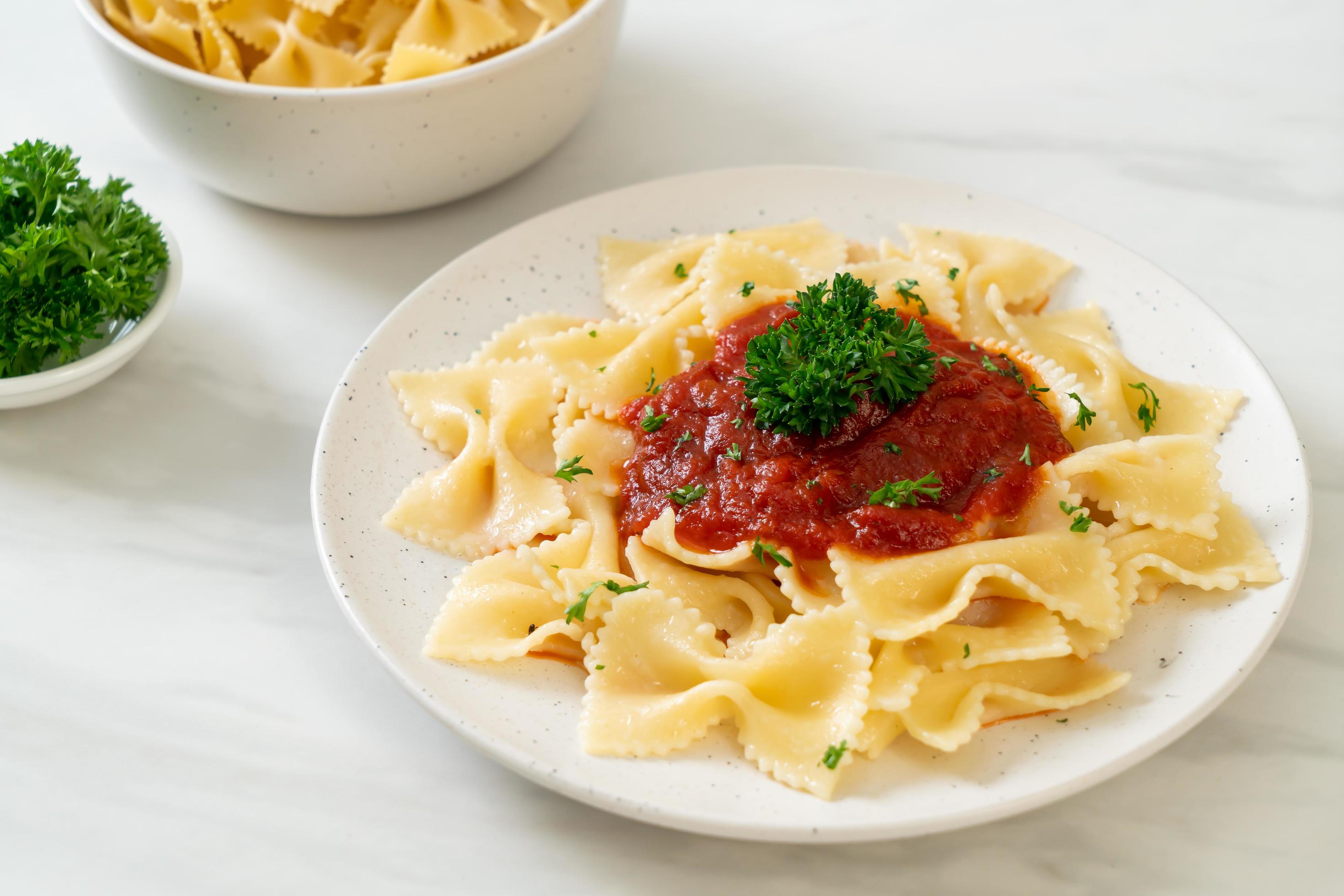 Farfalle pasta in tomato sauce with parsley – Italian food style Stock Free