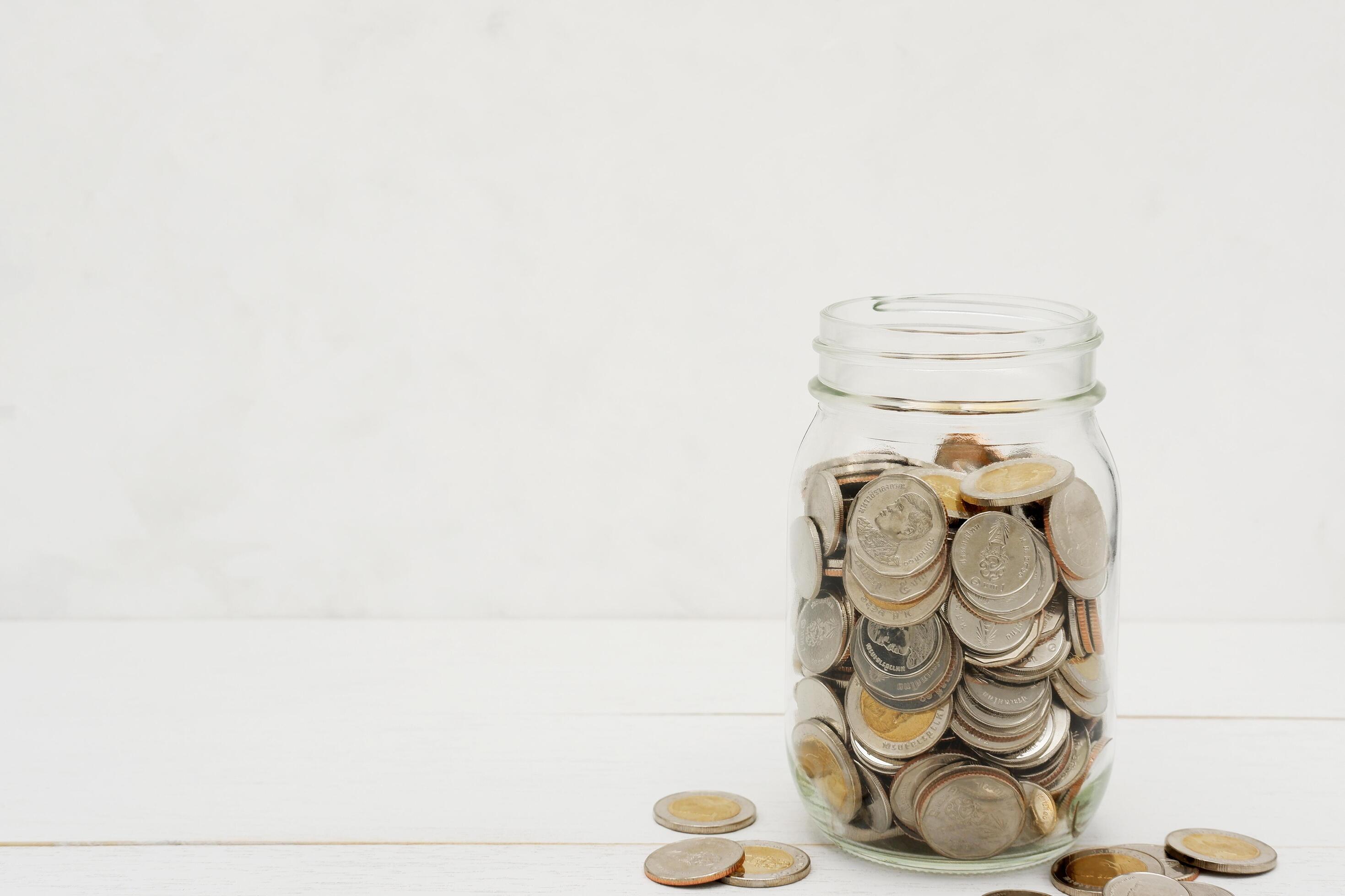 Thai Baht coins in a glass jar. Business and finance concept. Stock Free