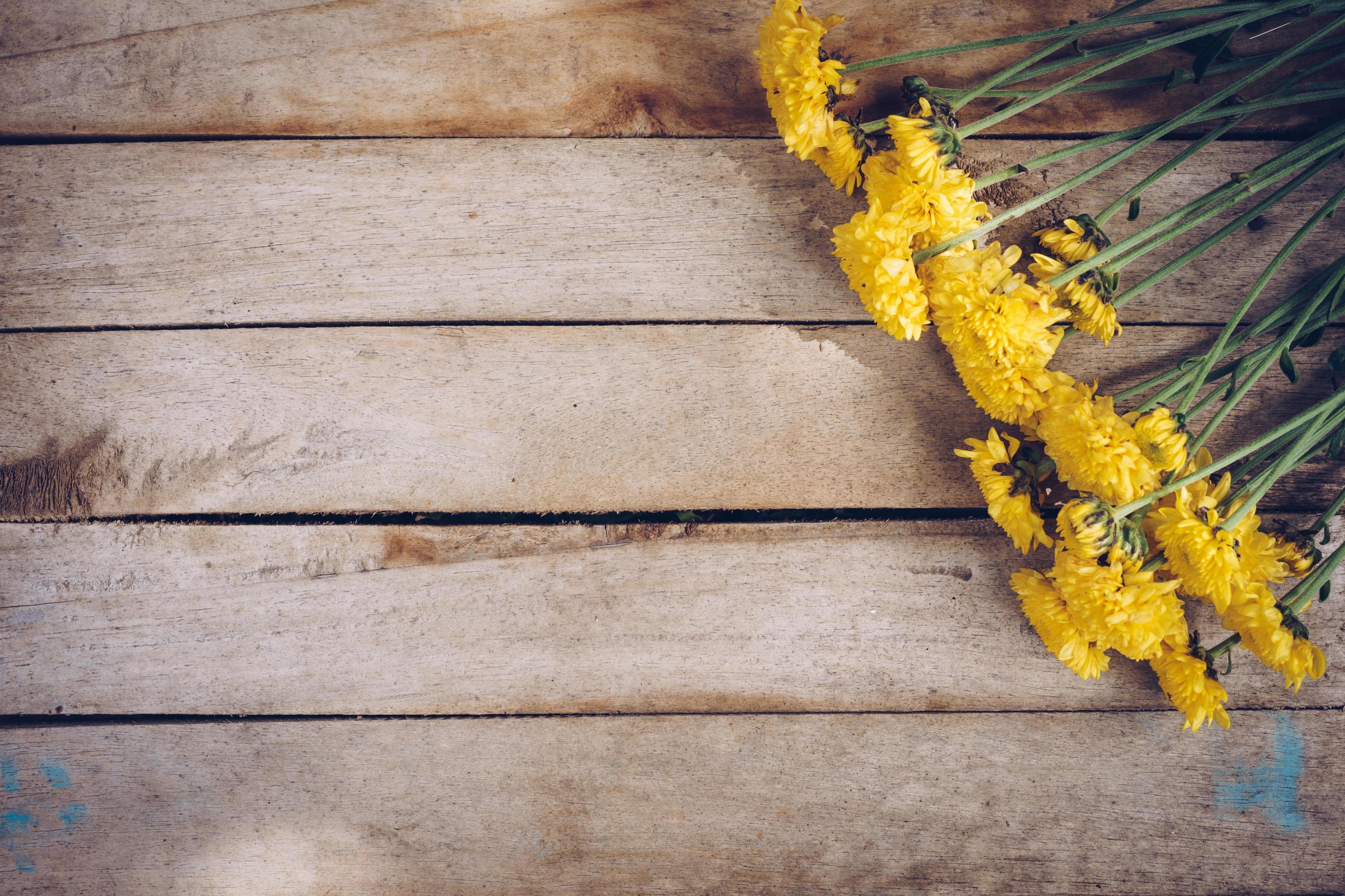 Yellow flowers of bouquet, top view on wooden background texture with copy space Stock Free