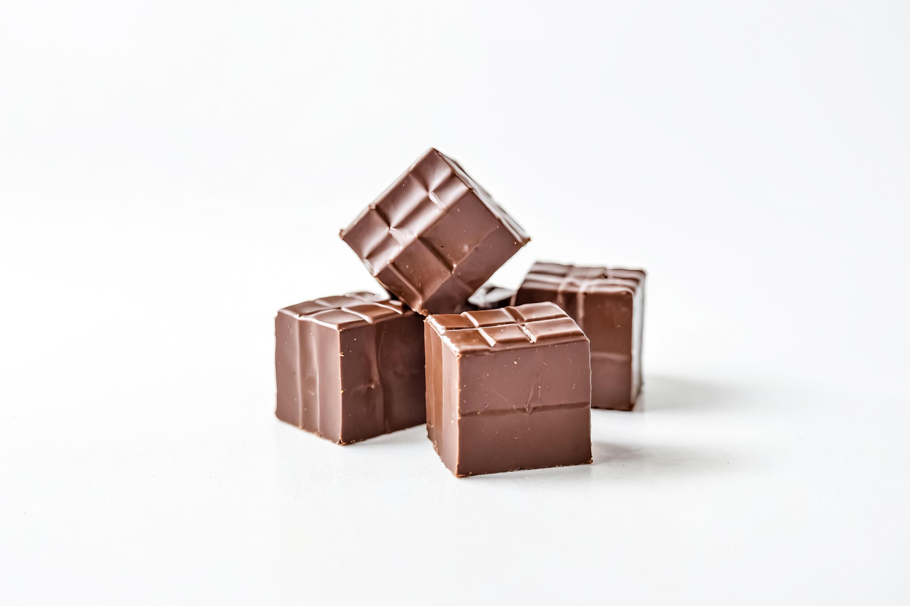 Close up of four milk chocolate squares on white background Stock Free