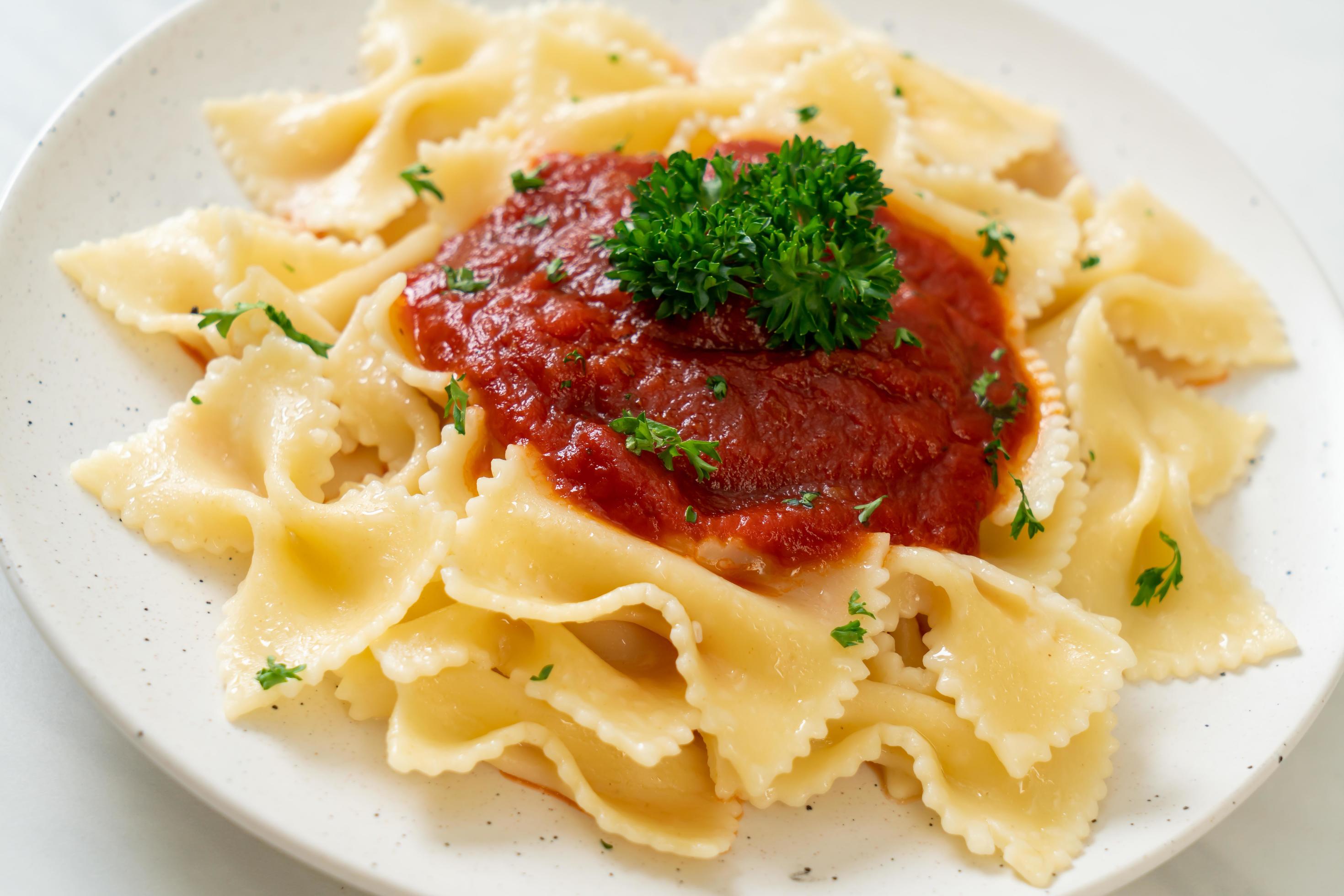 Farfalle pasta in tomato sauce with parsley – Italian food style Stock Free