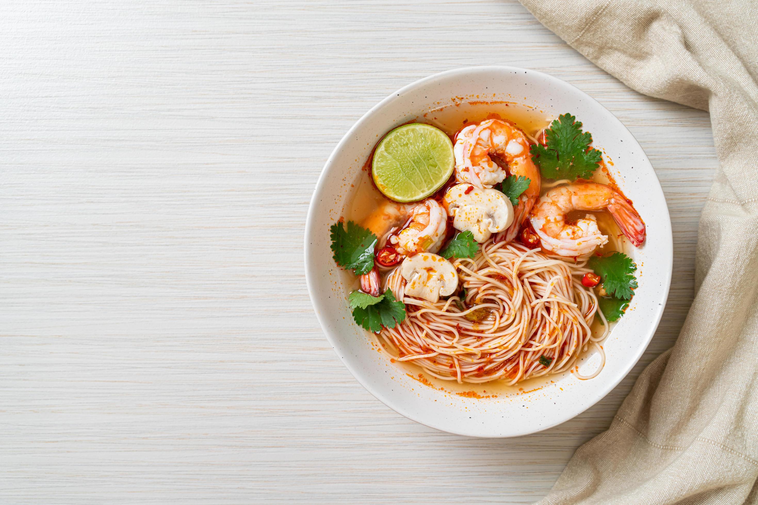 
									Noodles with spicy soup and shrimps in white bowl, or Tom Yum Kung – Asian food style Stock Free