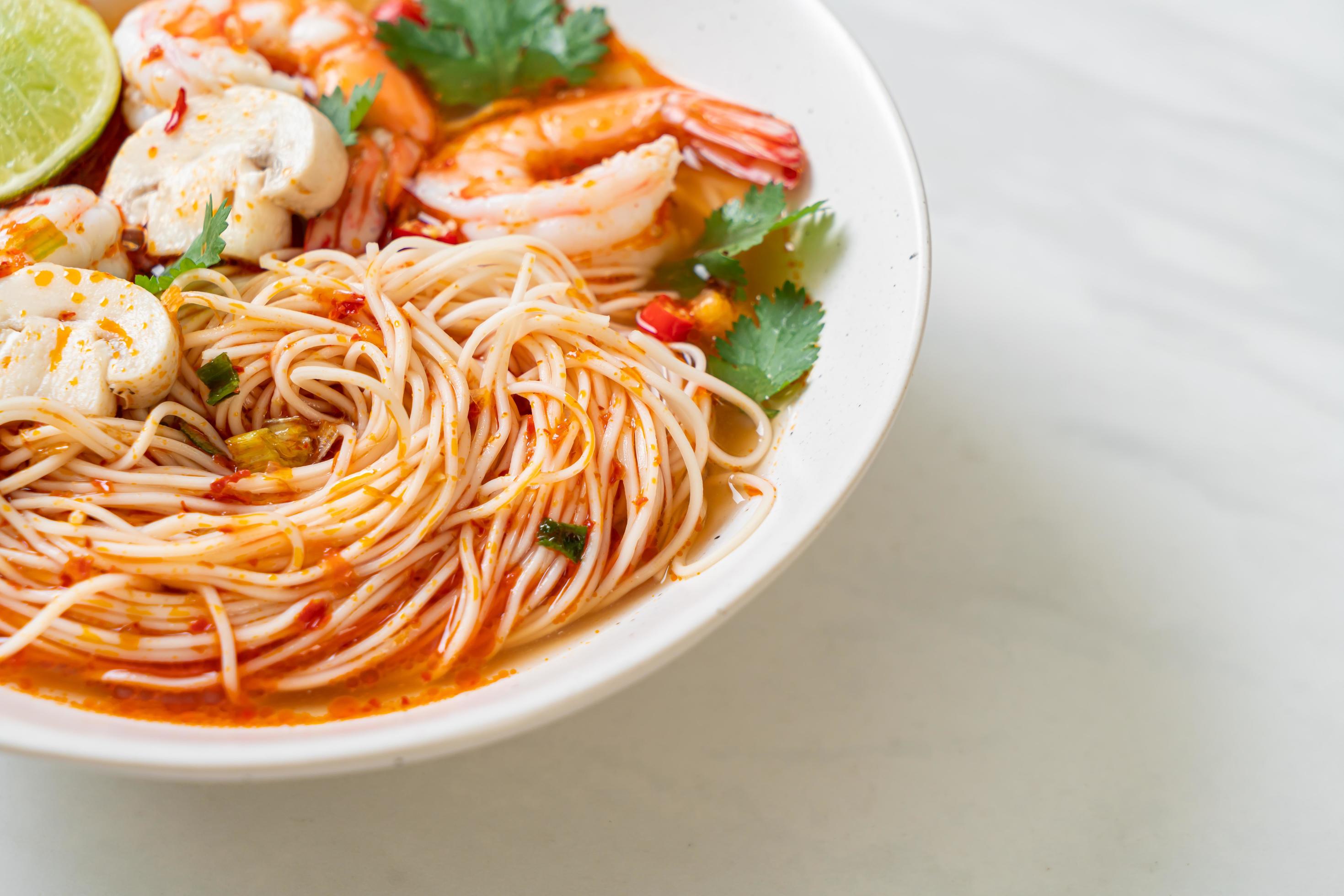 
									Noodles with spicy soup and shrimps in white bowl, or Tom Yum Kung – Asian food style Stock Free