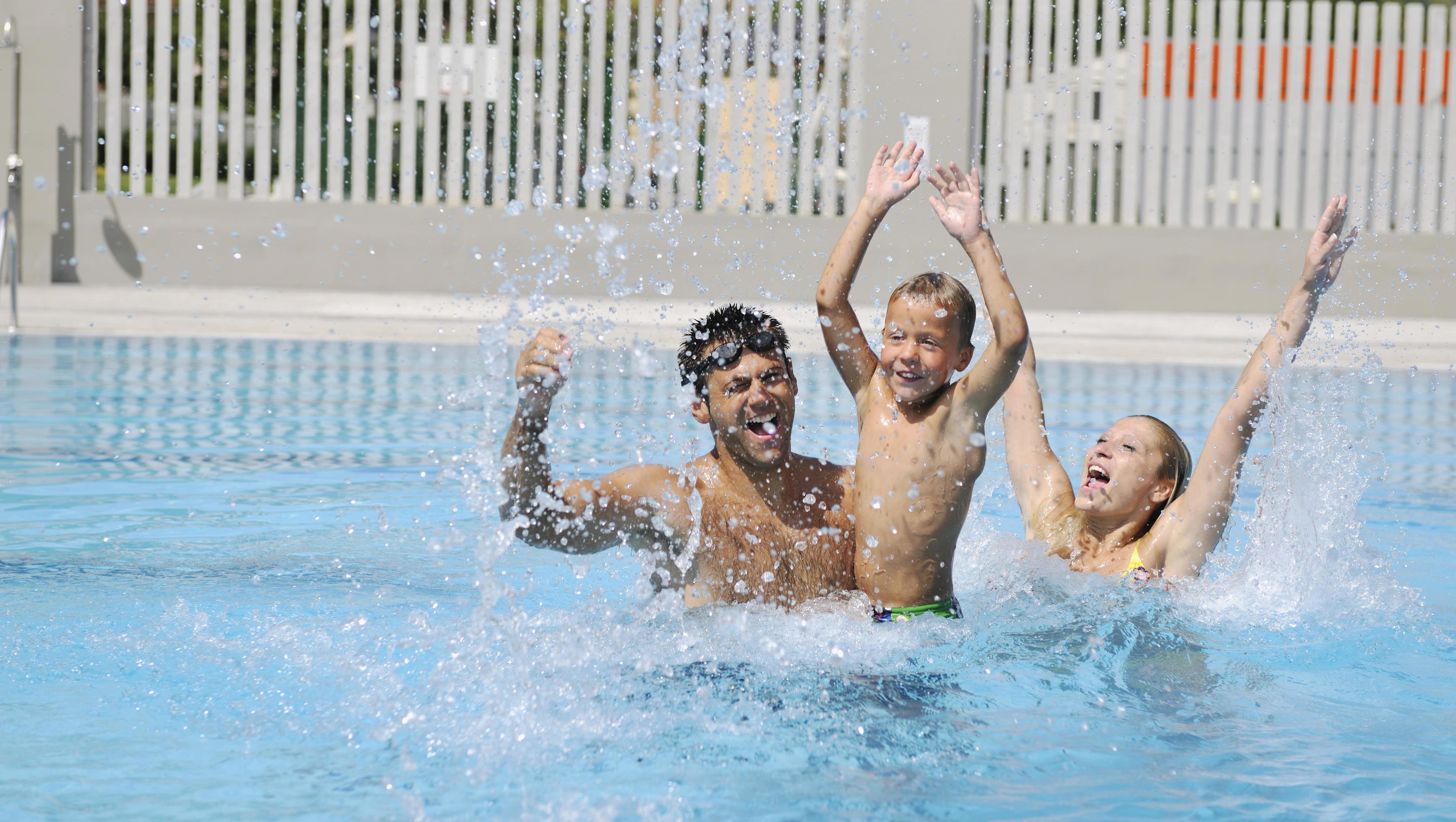 happy young family have fun on swimming pool Stock Free