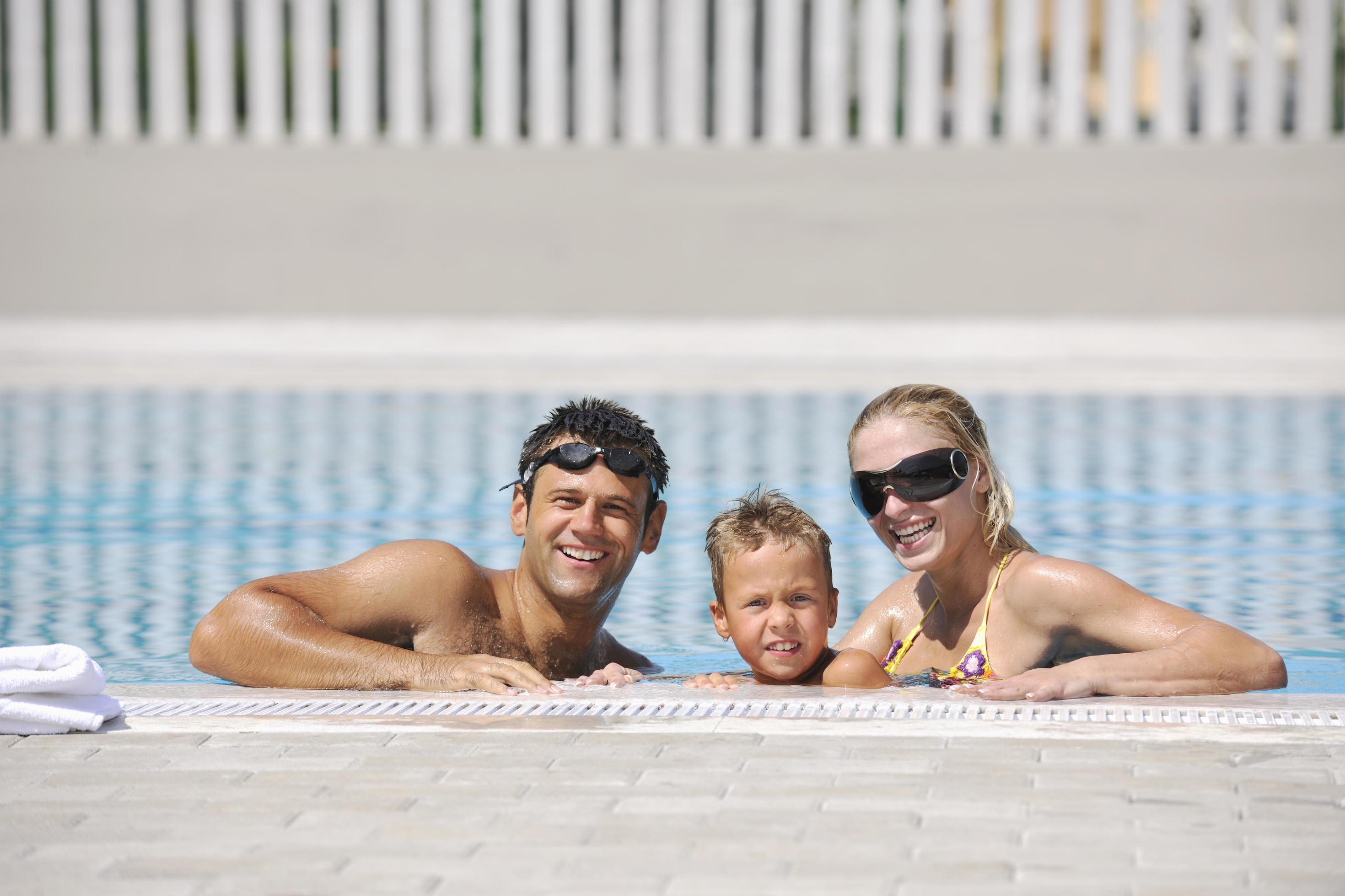 happy young family have fun on swimming pool Stock Free