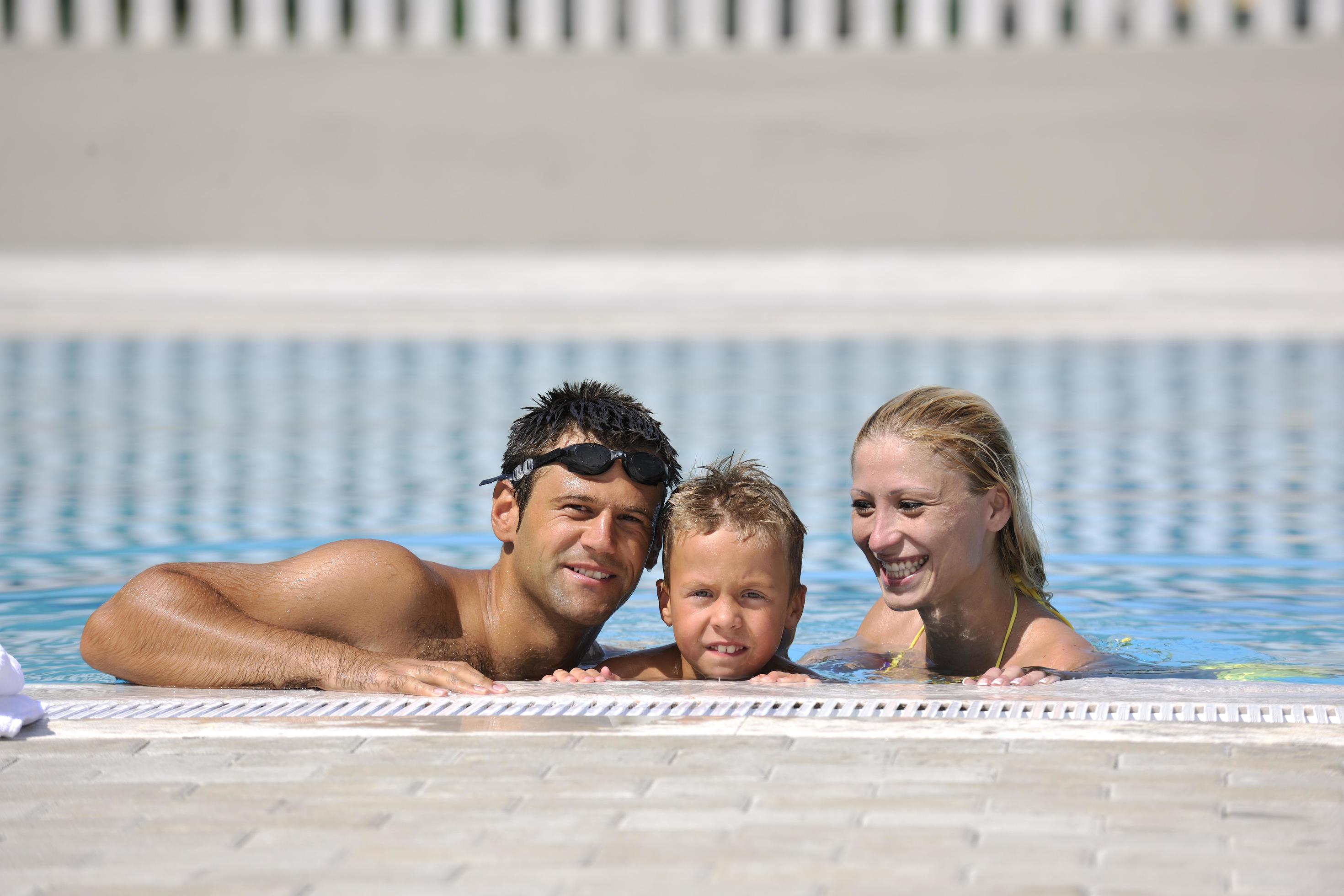 happy young family have fun on swimming pool Stock Free