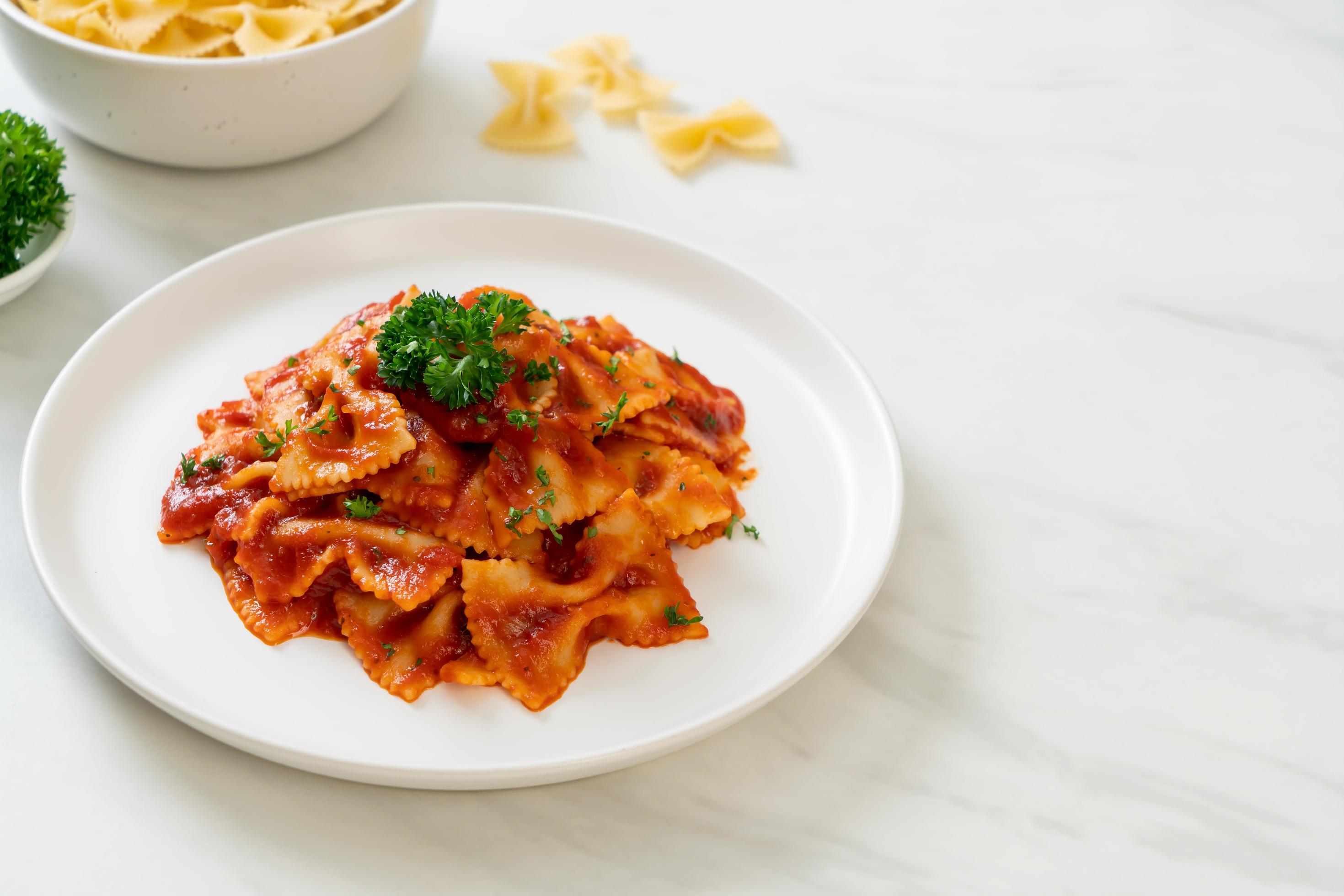 Farfalle pasta in tomato sauce with parsley – Italian food style Stock Free