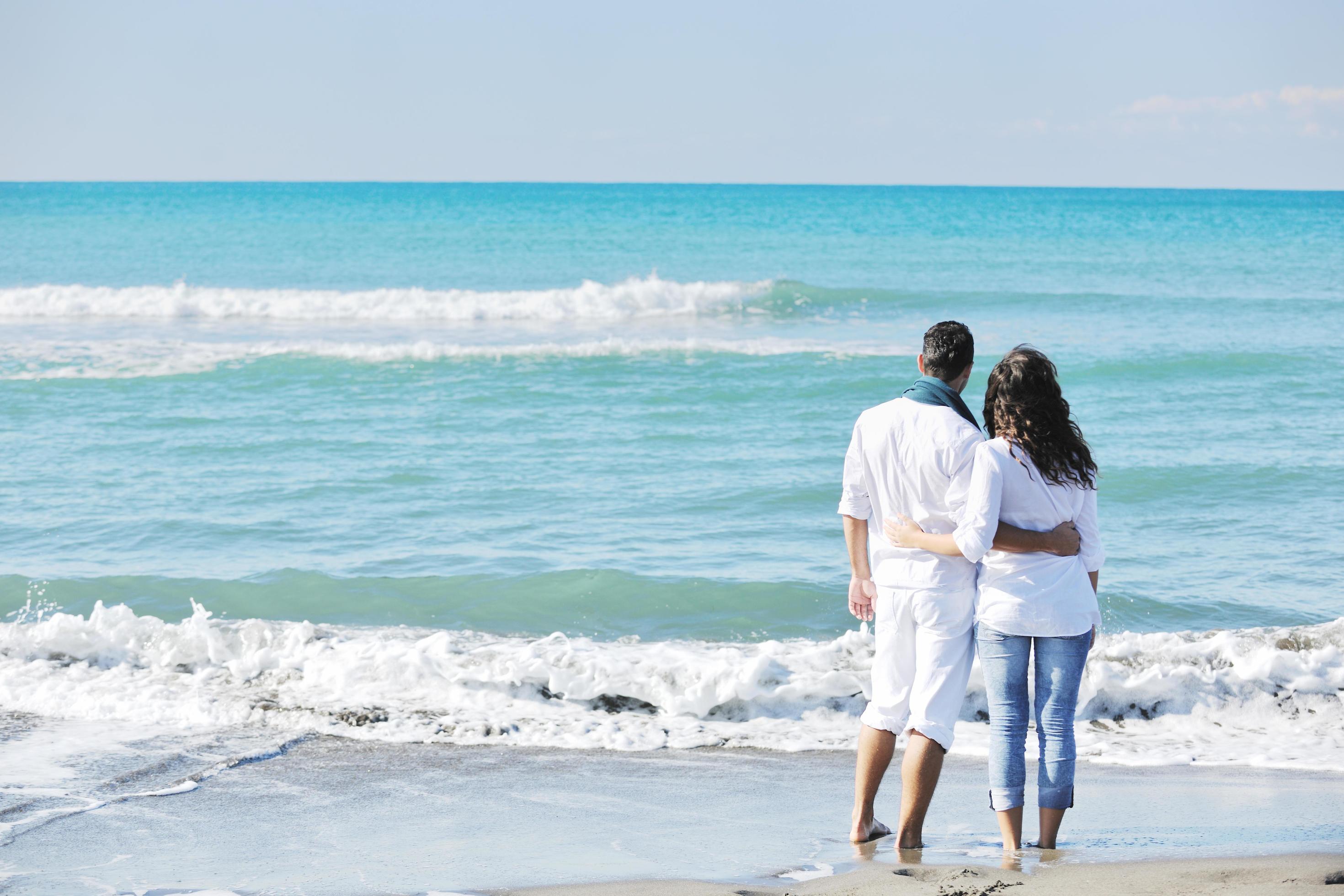 happy young couple have fun at beautiful beach Stock Free