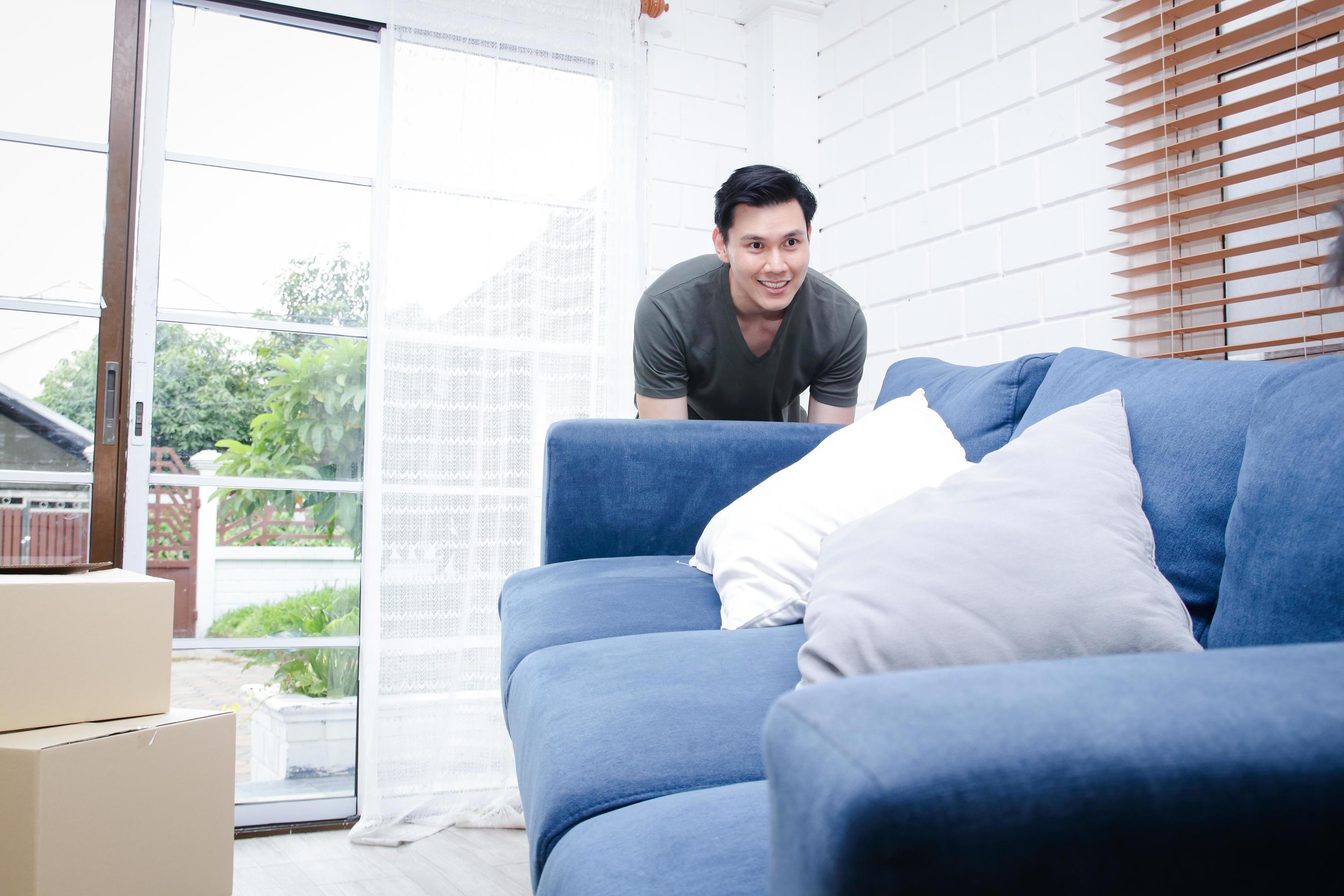 An Asian man moves into a new home. Help each other move the sofa to the living room. Concept of starting a new life, building a family Stock Free