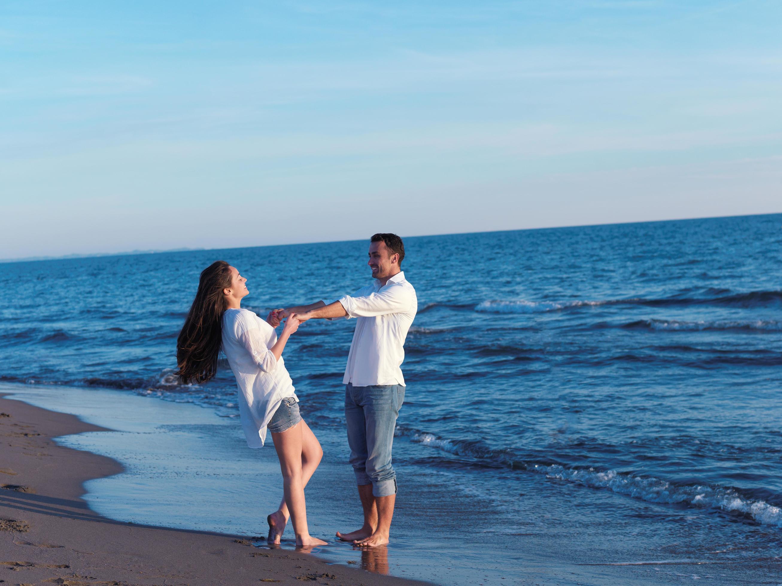 young couple on beach have fun Stock Free