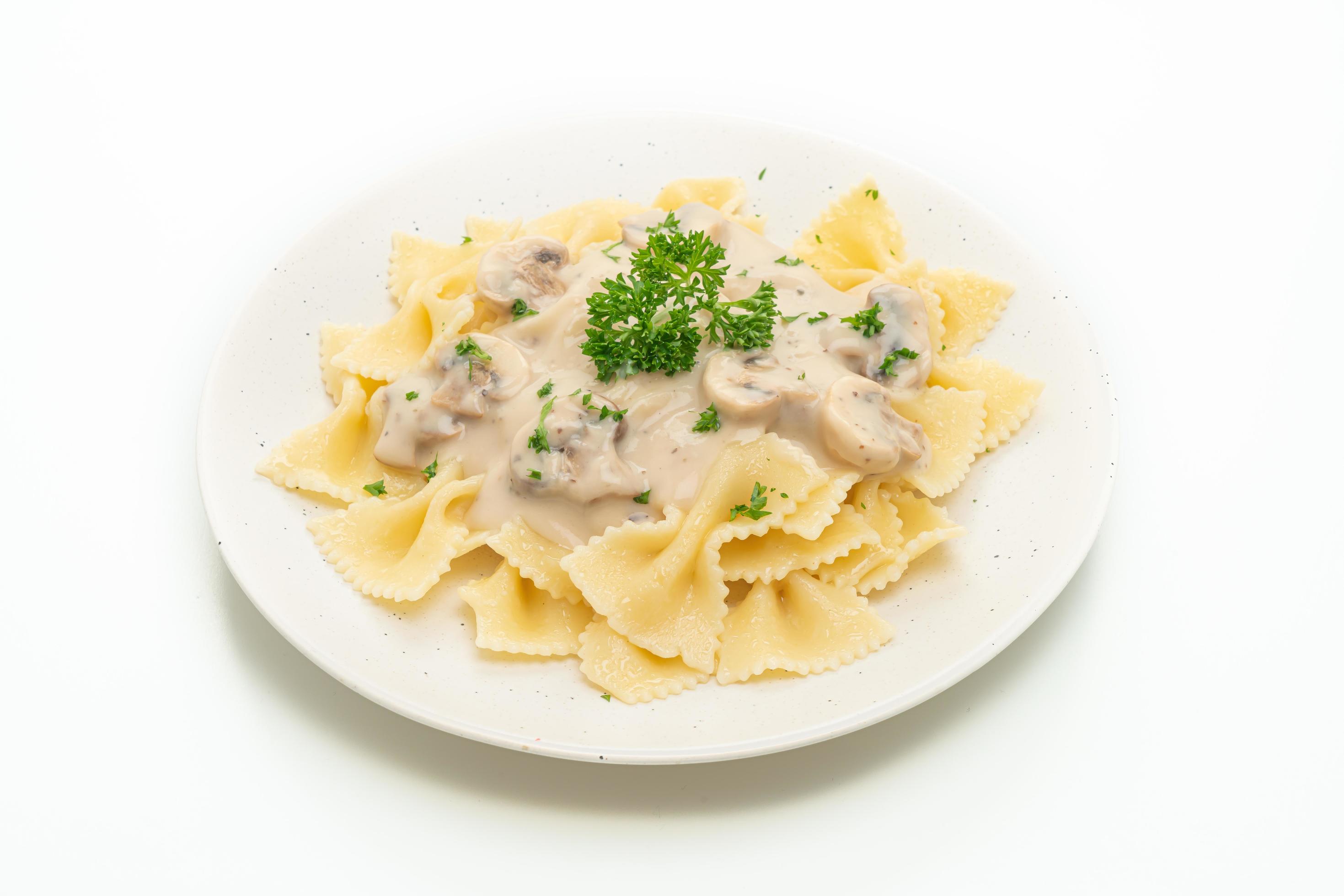 Farfalle pasta with mushroom white cream sauce – Italian food style Stock Free