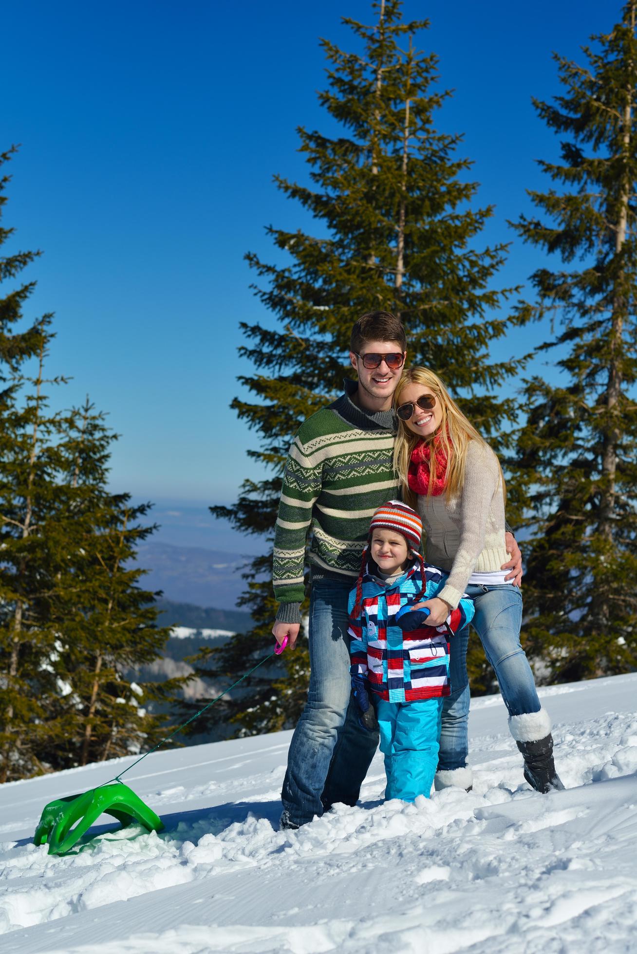 family having fun on fresh snow at winter vacation Stock Free