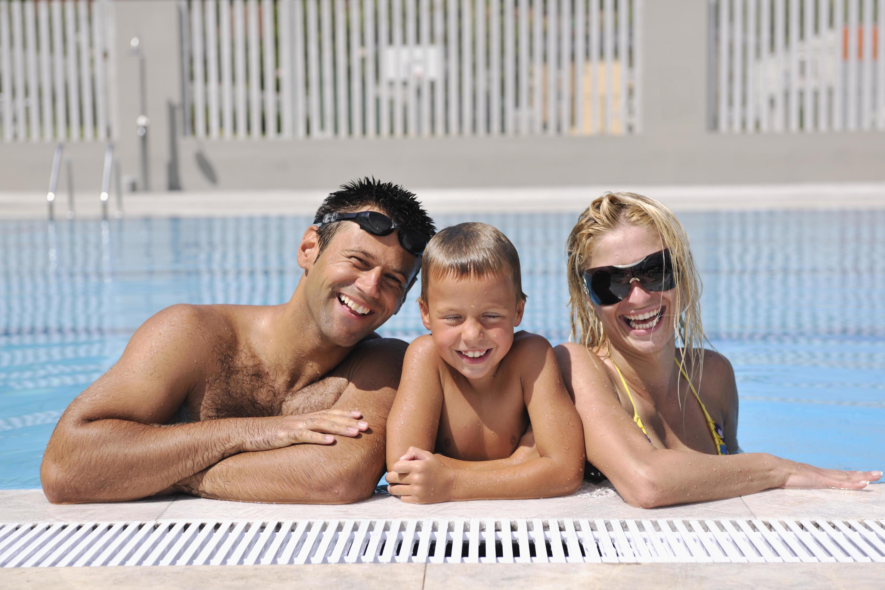 happy young family have fun on swimming pool Stock Free