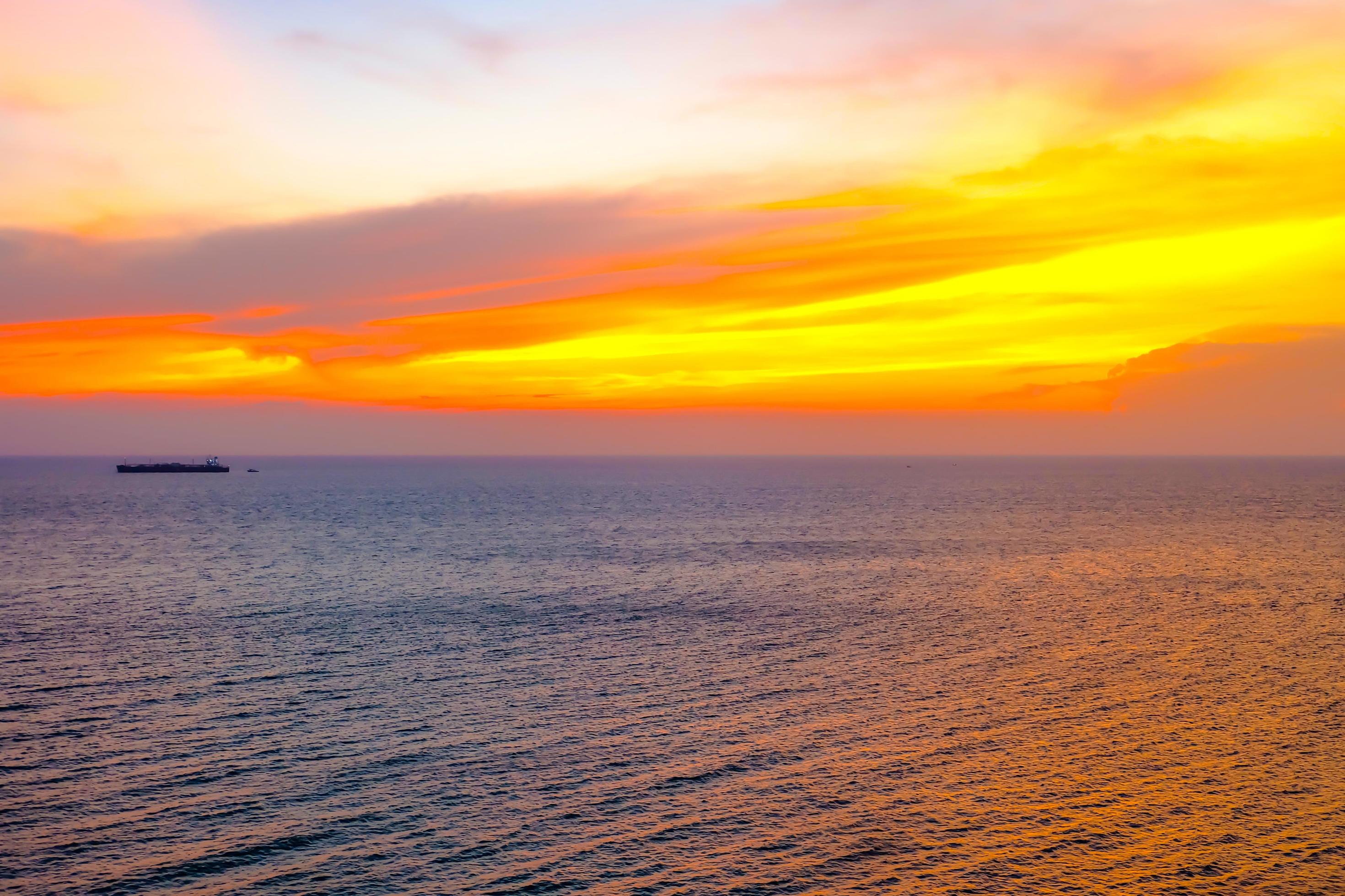 Colorfull sunset on the sea of Silhoutte Cargo Ship nature background Stock Free