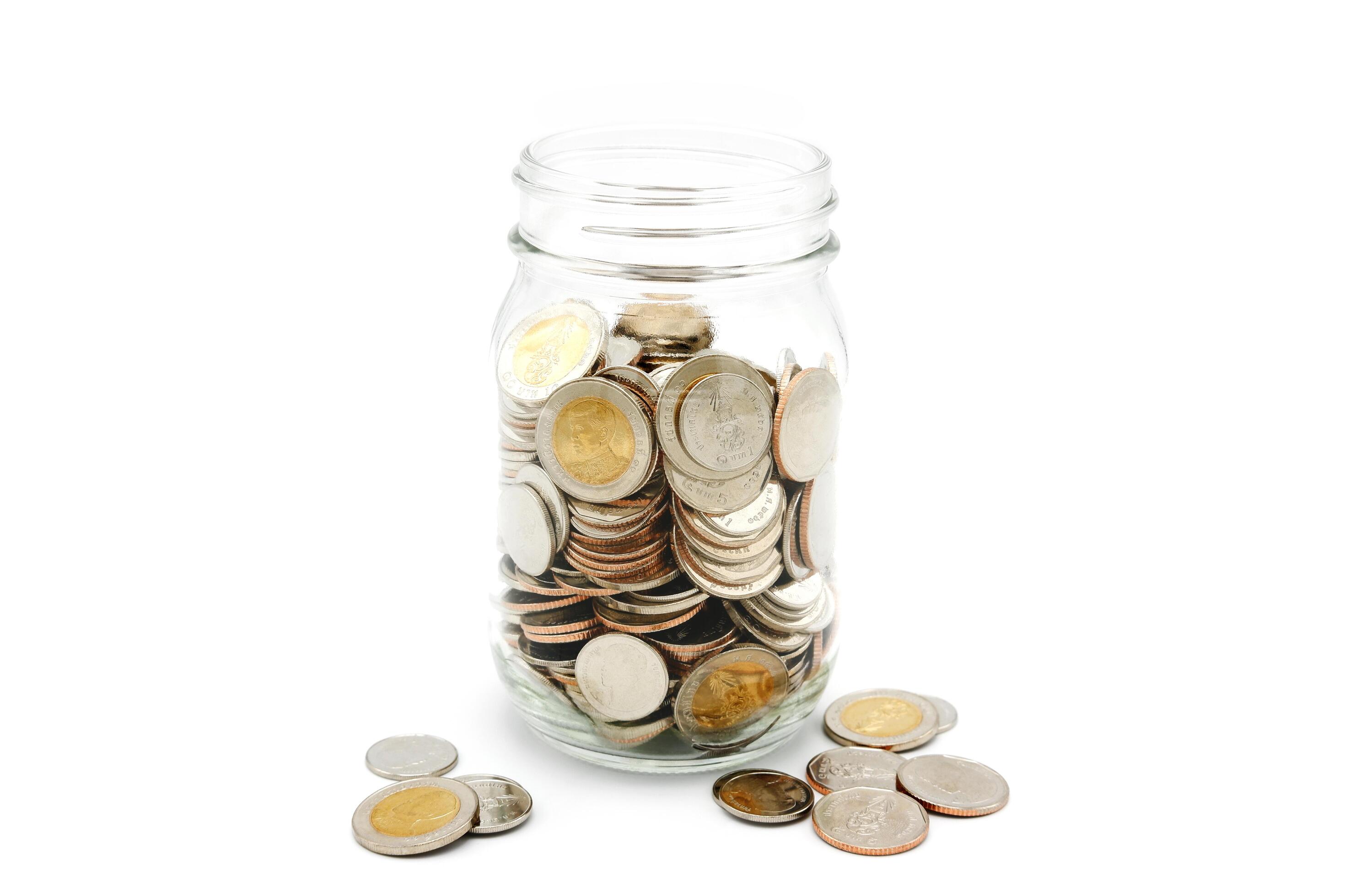 Thai Baht coins in a glass jar. Business and finance concept. Stock Free