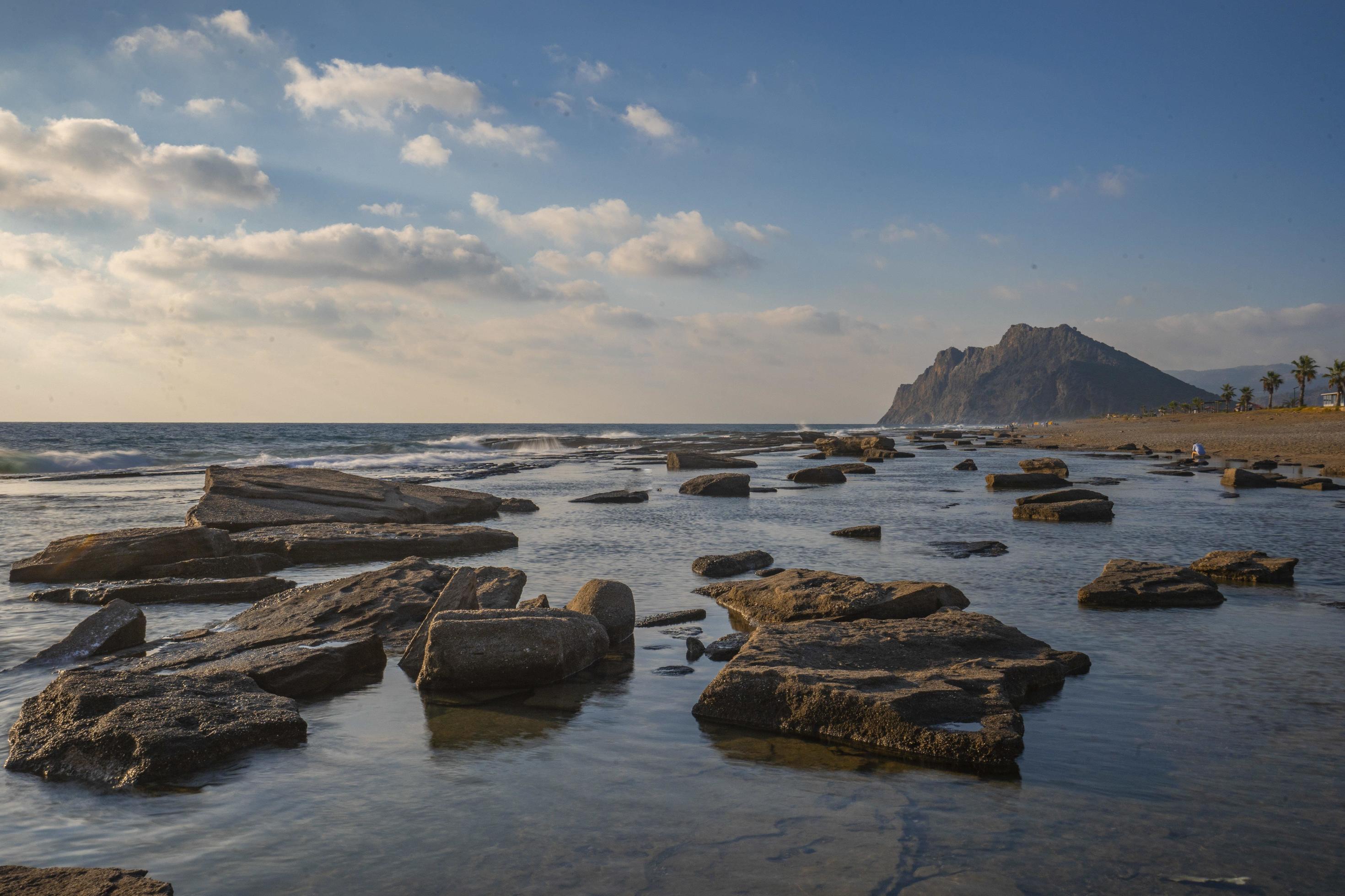 Long exposure photography of waves and pebbles on Beach in the sunset Stock Free