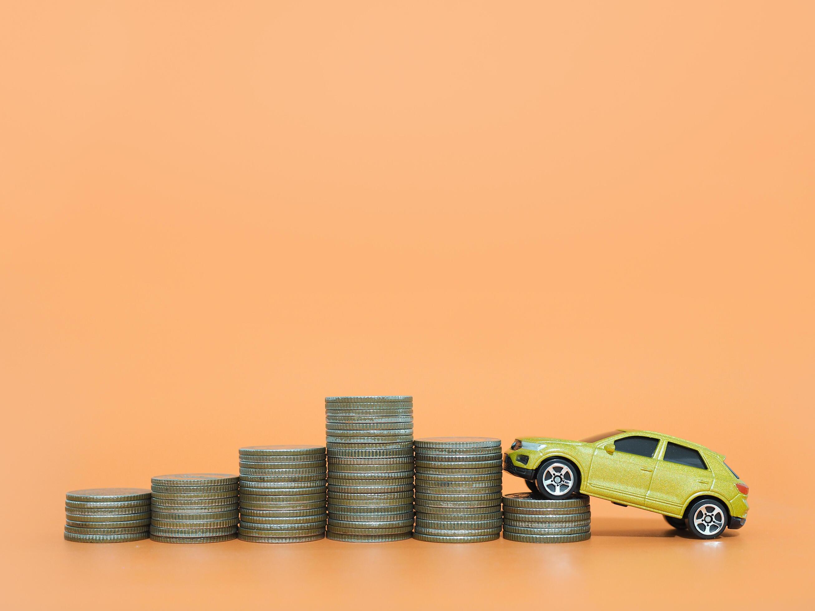 Toy car and stack of coins. The concept of saving money and manage to success transport business Stock Free